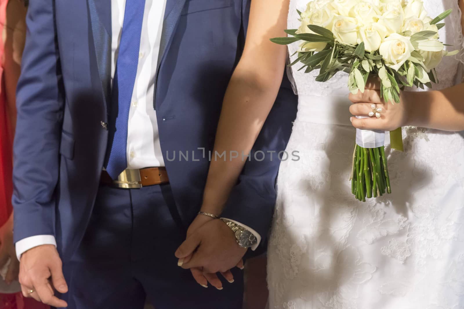 young wedding couple holding their hands in ceremony