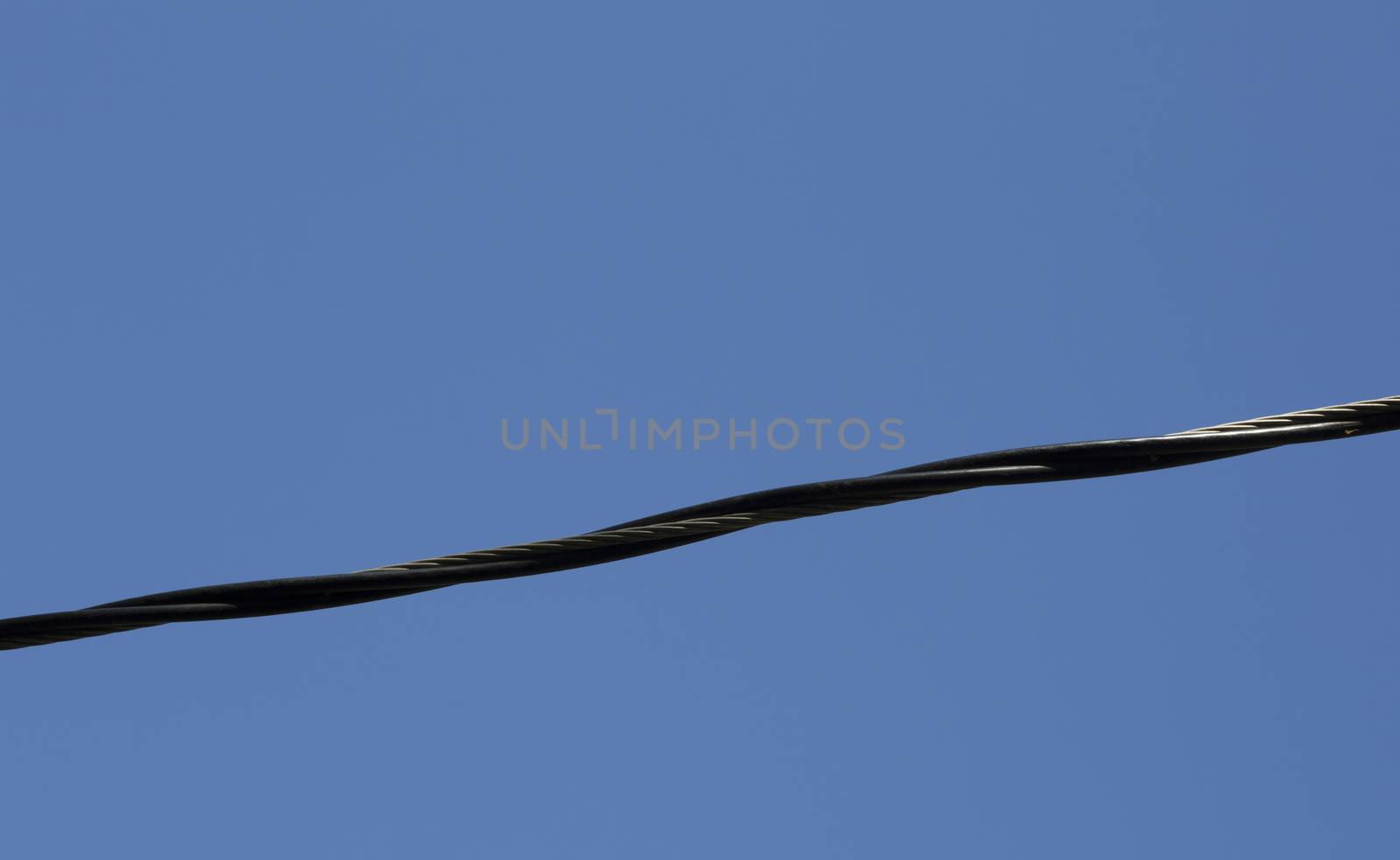 Close up of an electrical line against the deep blue sky