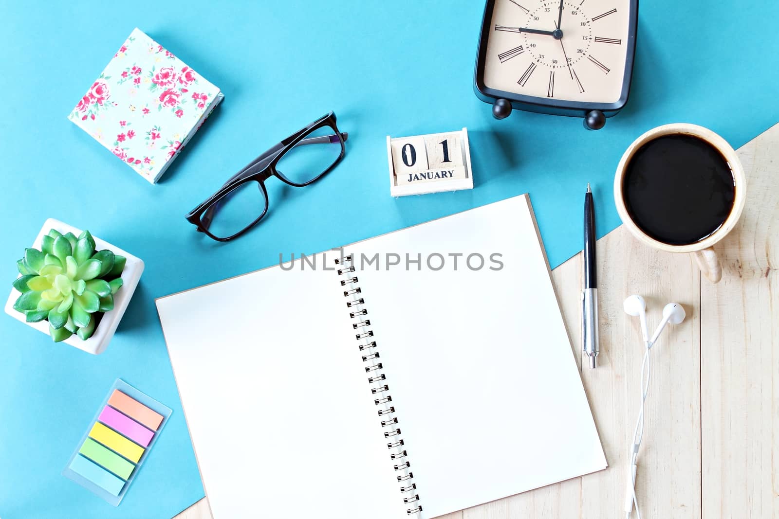 Business, weekend, holiday or new year planning concept : Top view or flat lay of open notebook paper, accessories, cube calendar and coffee cup on wooden background, ready for adding or mock up