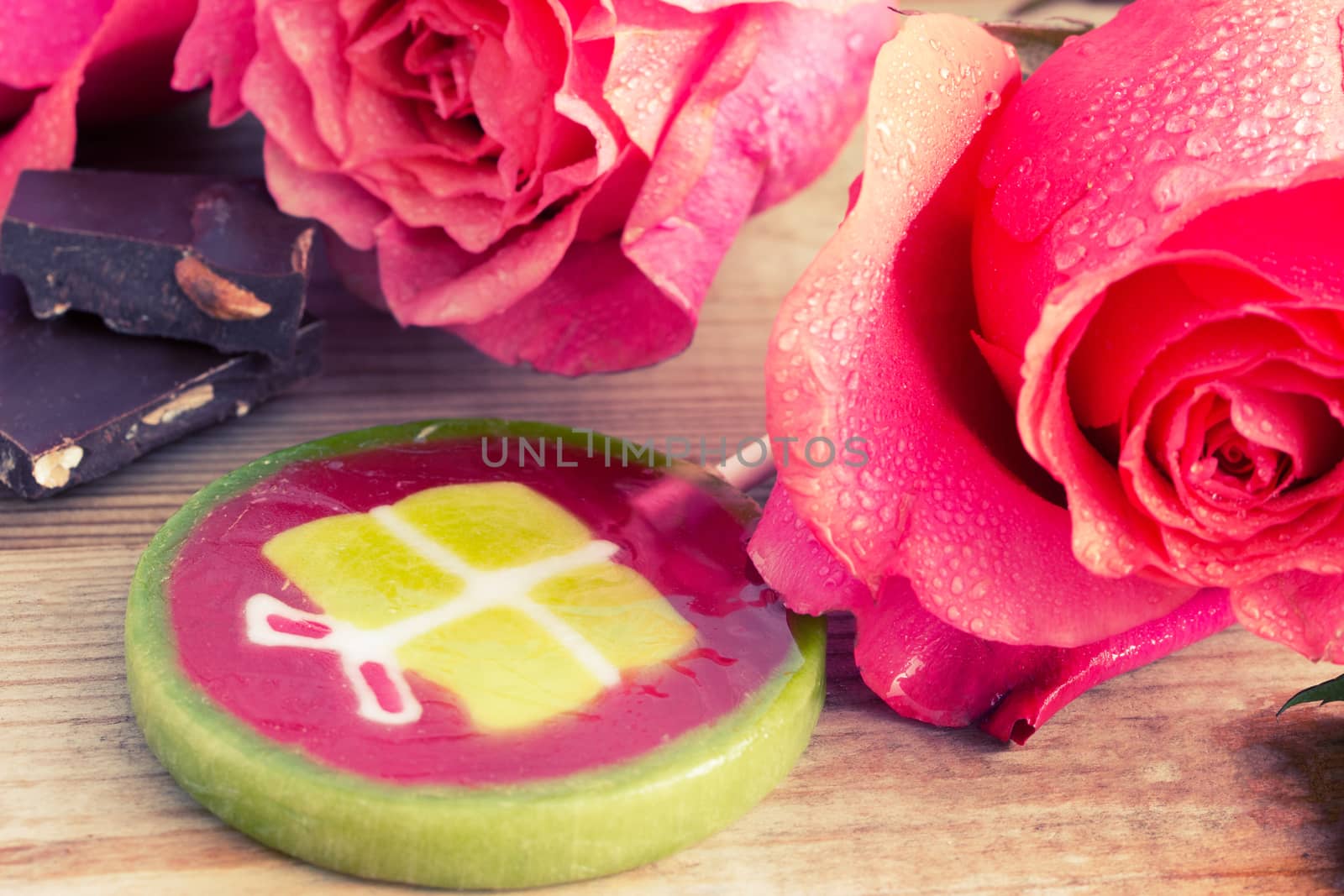 pink roses and lollipop on wooden table. holiday concept