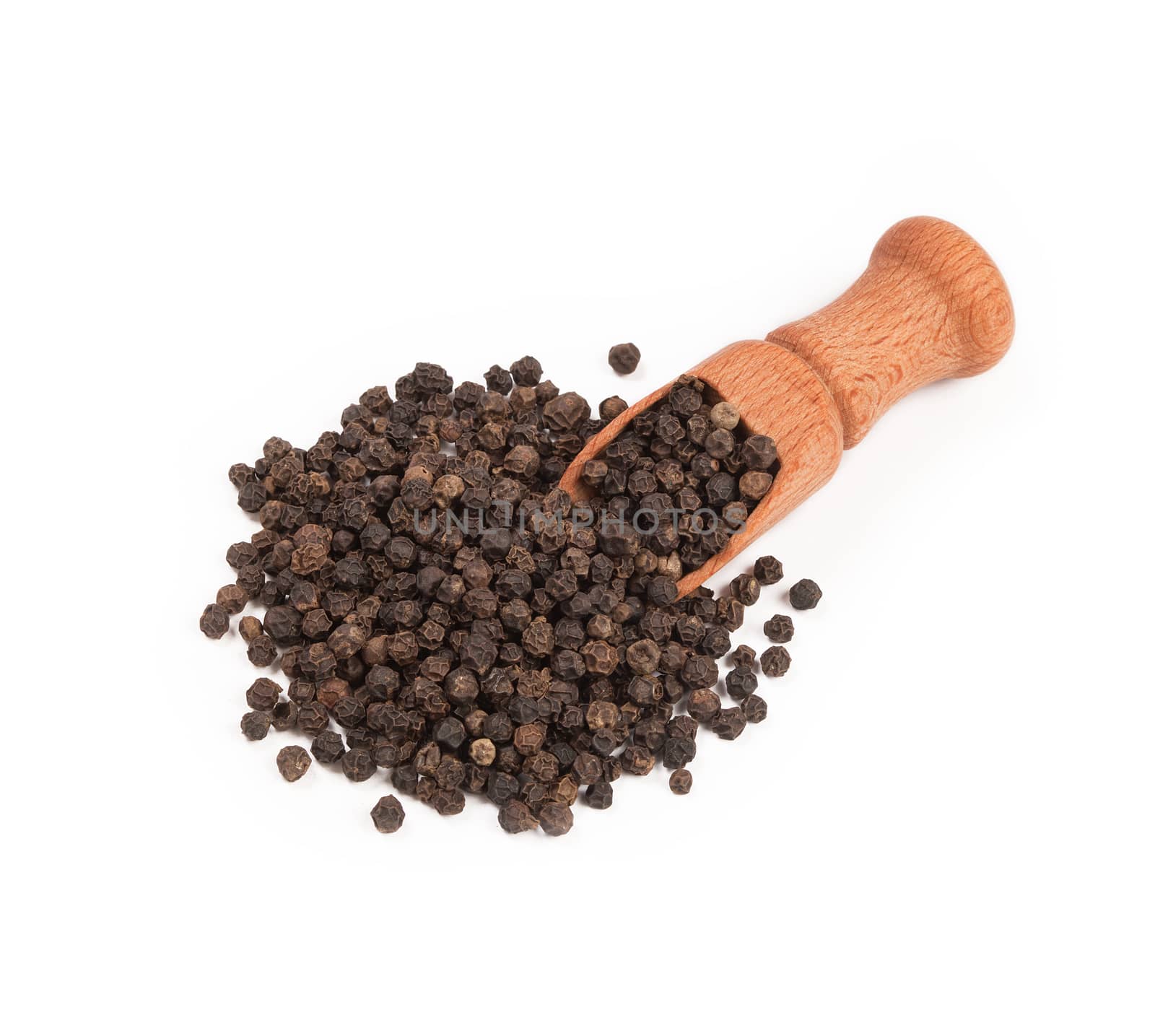 Wooden shovel with black peppercorn scattered from it.