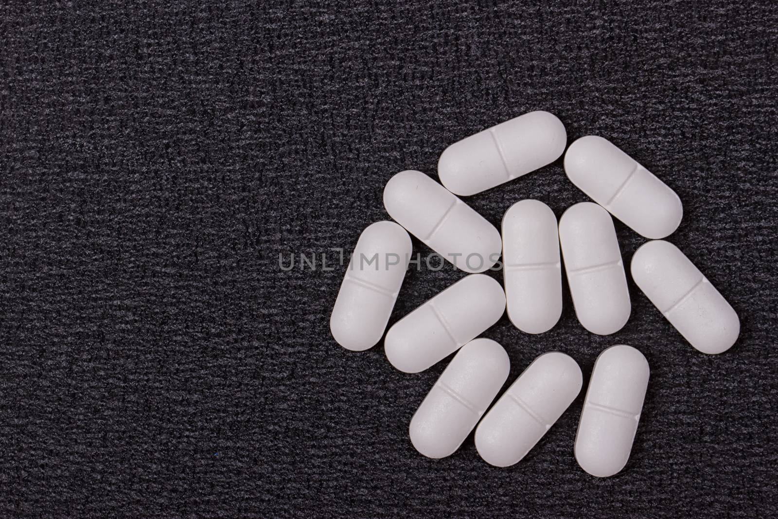 close up white pills on black background.