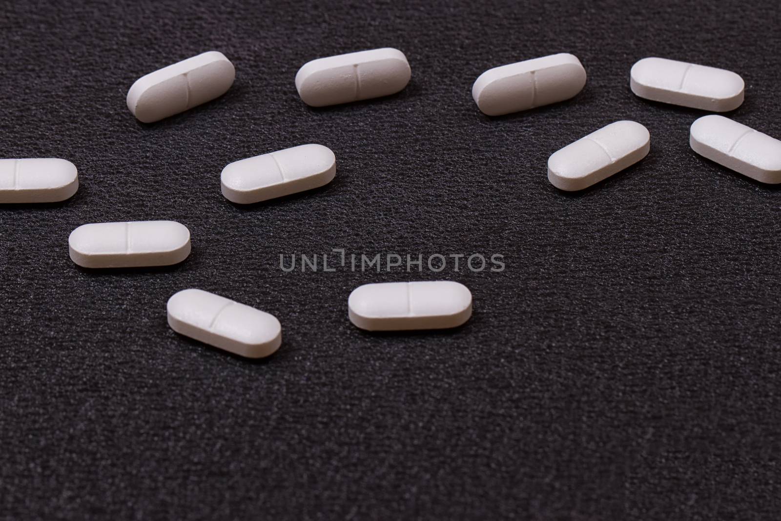 close up white pills on black background.