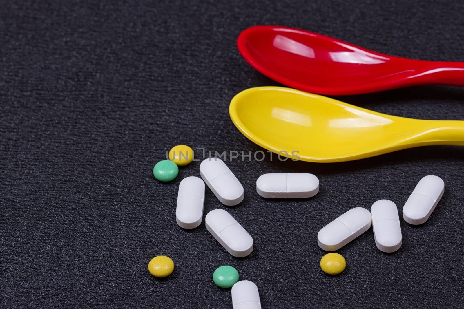 Assorted pharmaceutical medicine pills, tablets and capsules on spoon by victosha