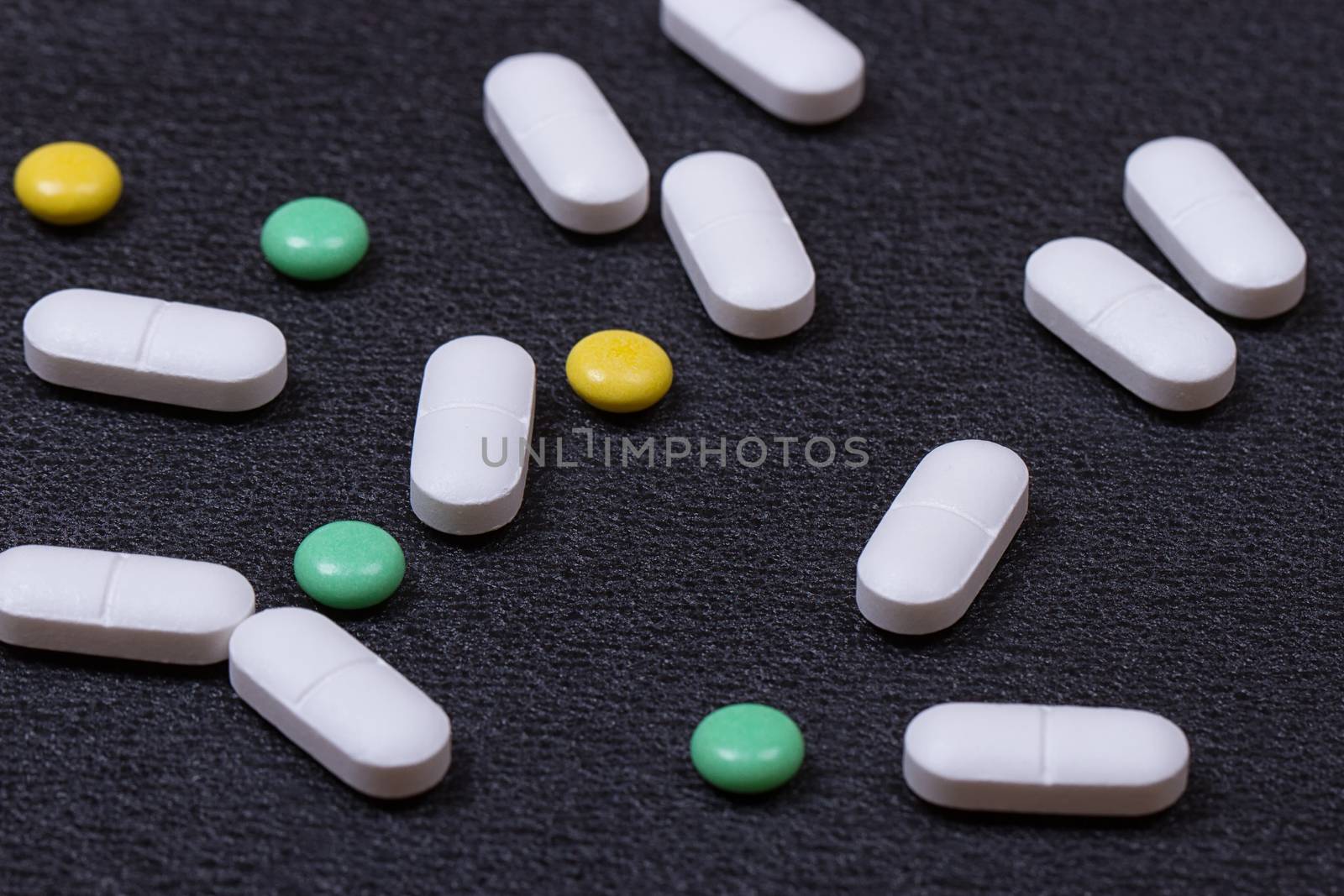 close up white pills on black background.