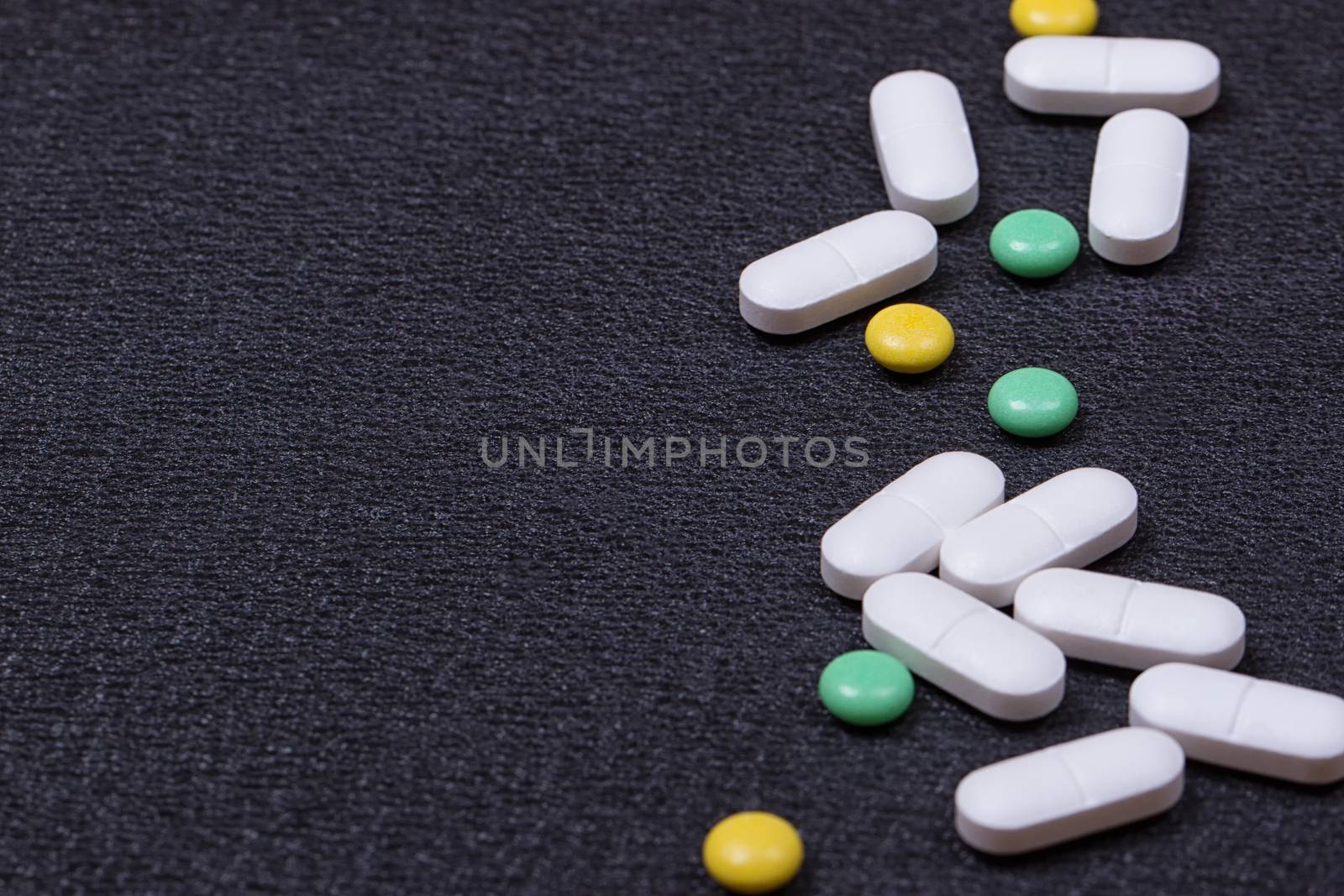 close up white pills on black background.