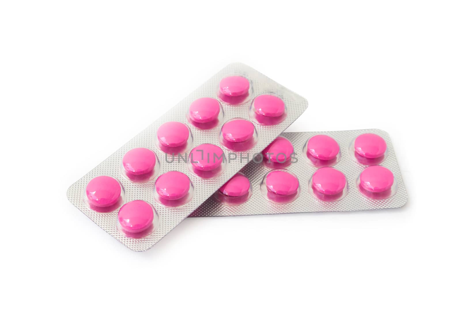 Pink pills in blister pack on white background