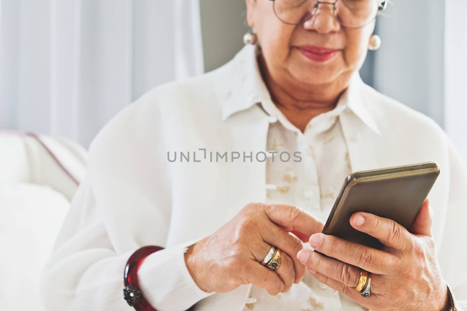 close up image of Senior woman using her mobile phone background.  An idea of modern lifestyle, communication,telecommunication,connectivity, social networking