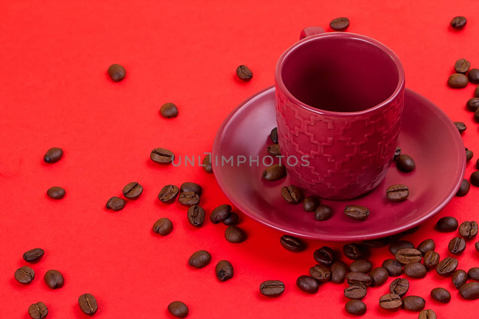 Empty coffee cup and coffee beans on a red background