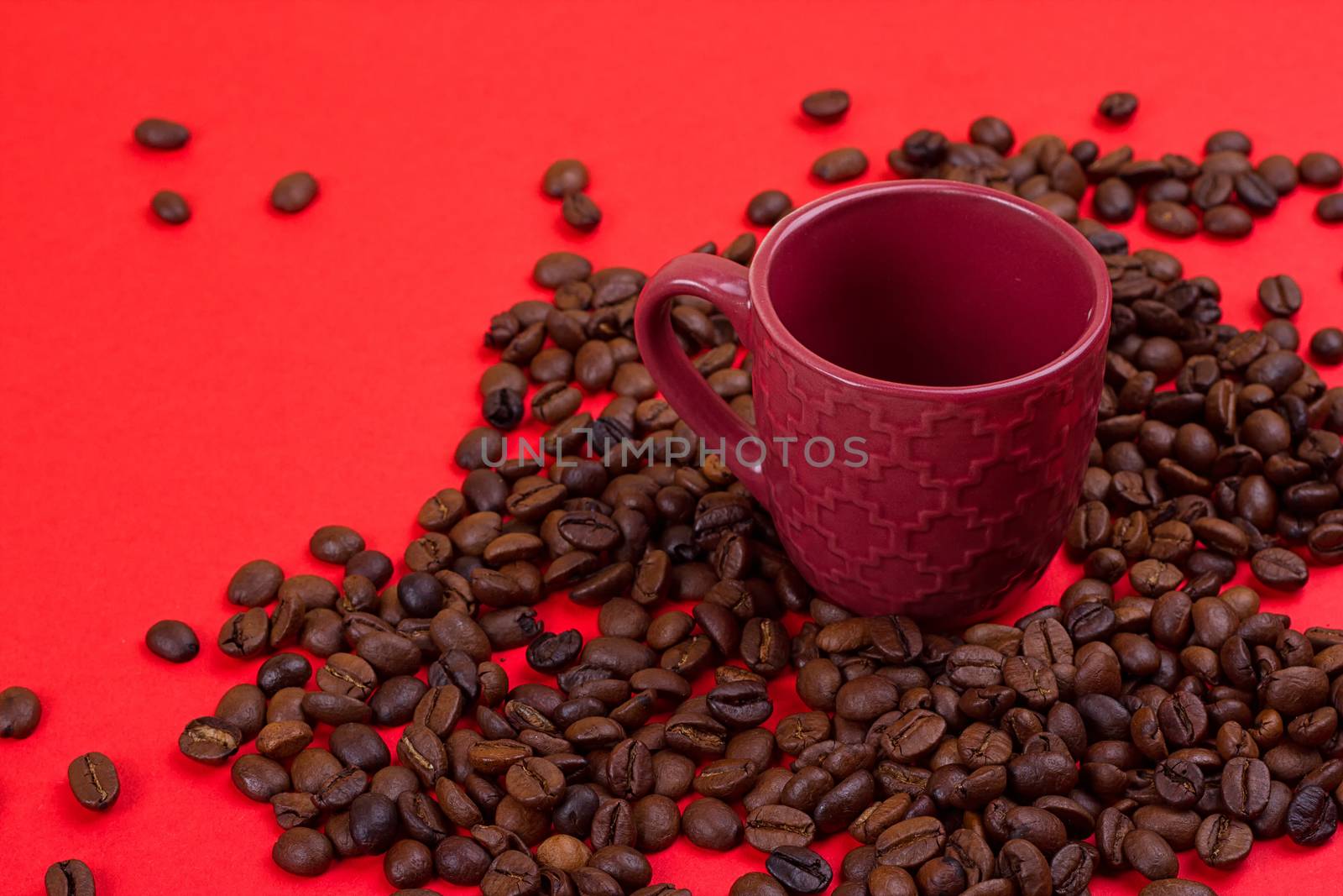 Empty coffee cup and coffee beans on a red background