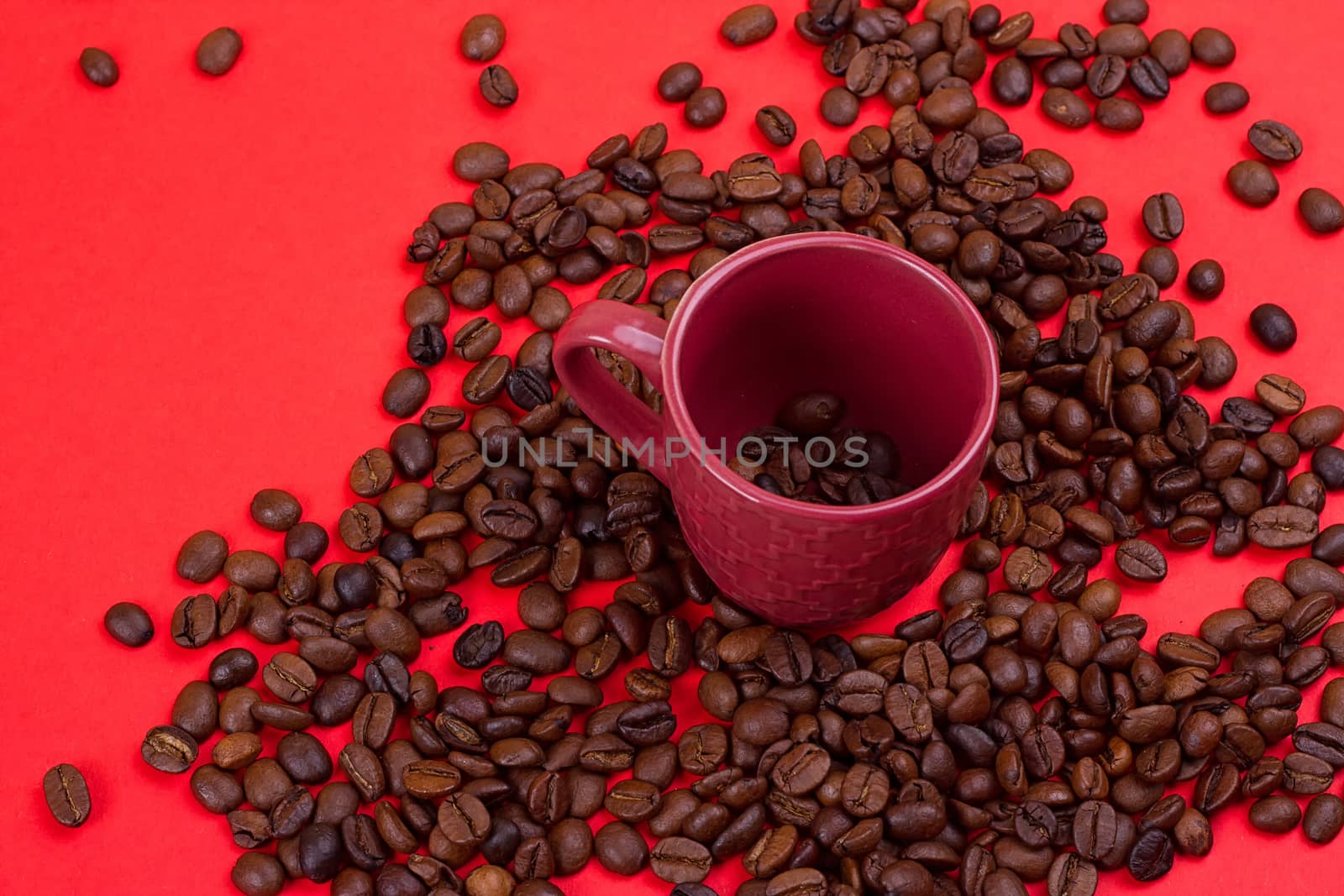Empty coffee cup and coffee beans on a red background