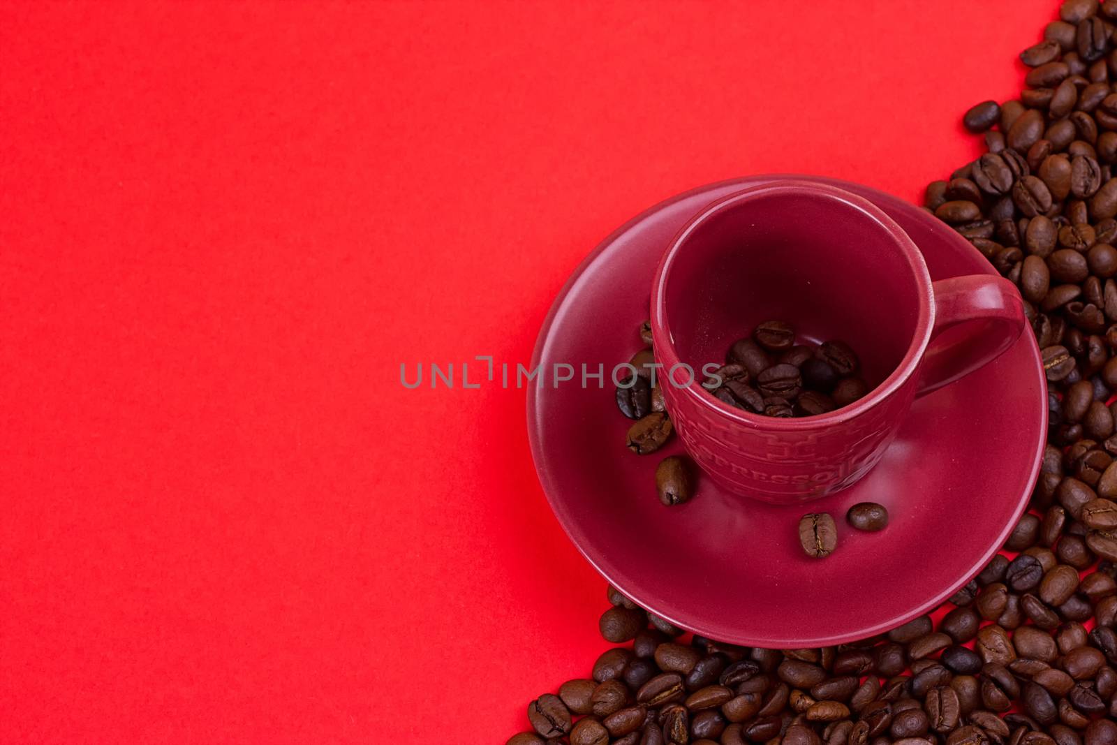 Empty coffee cup and coffee beans on a red background