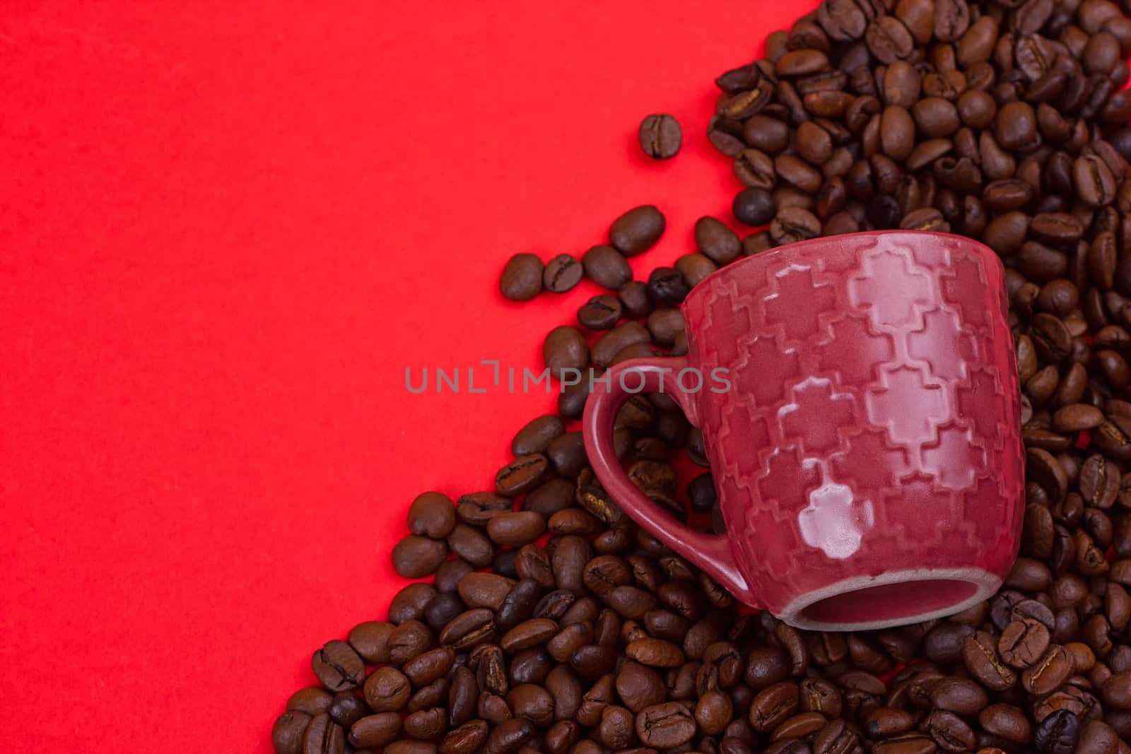 Empty coffee cup and coffee beans on a red background