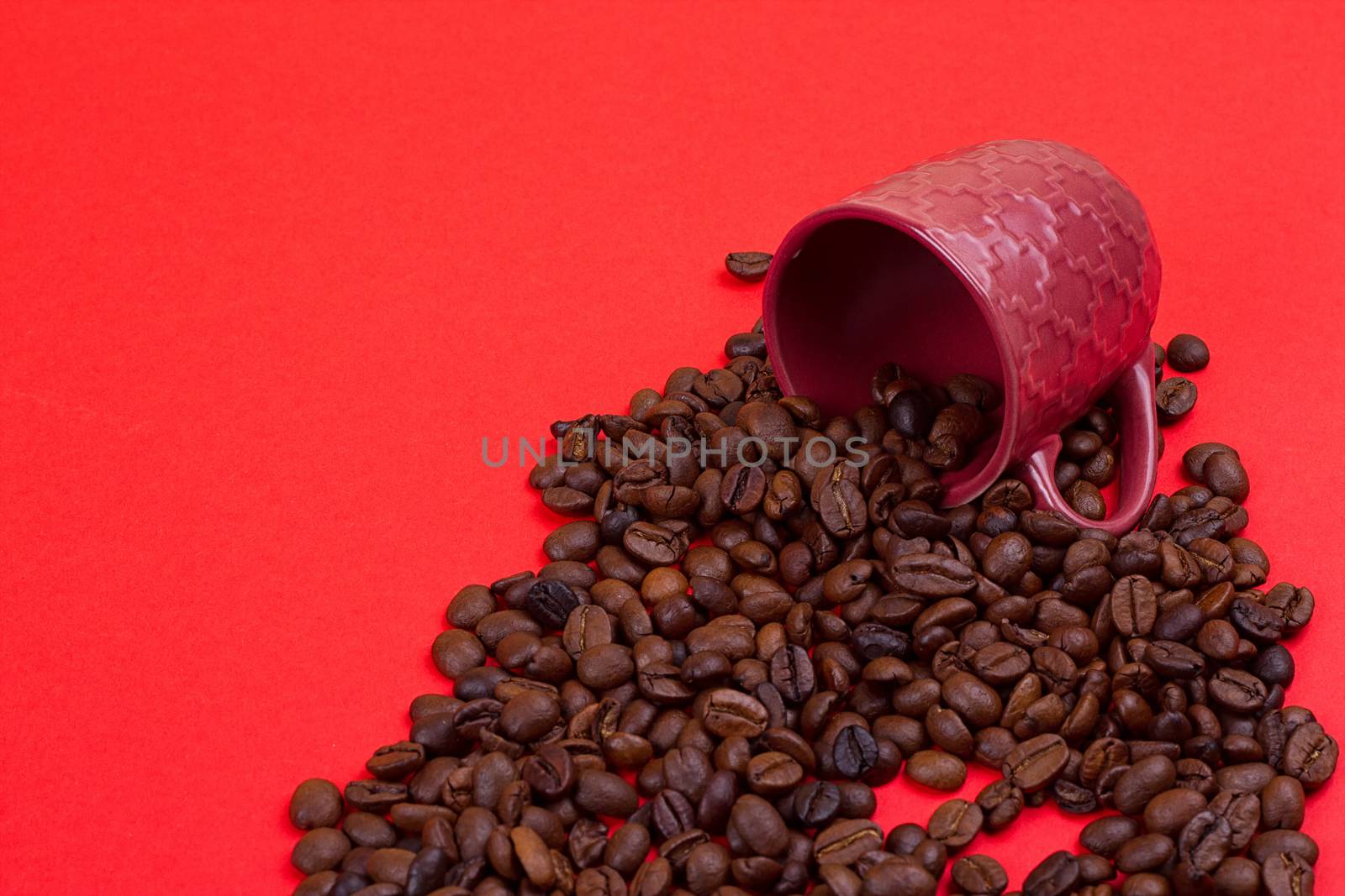 Empty coffee cup and coffee beans on a red background