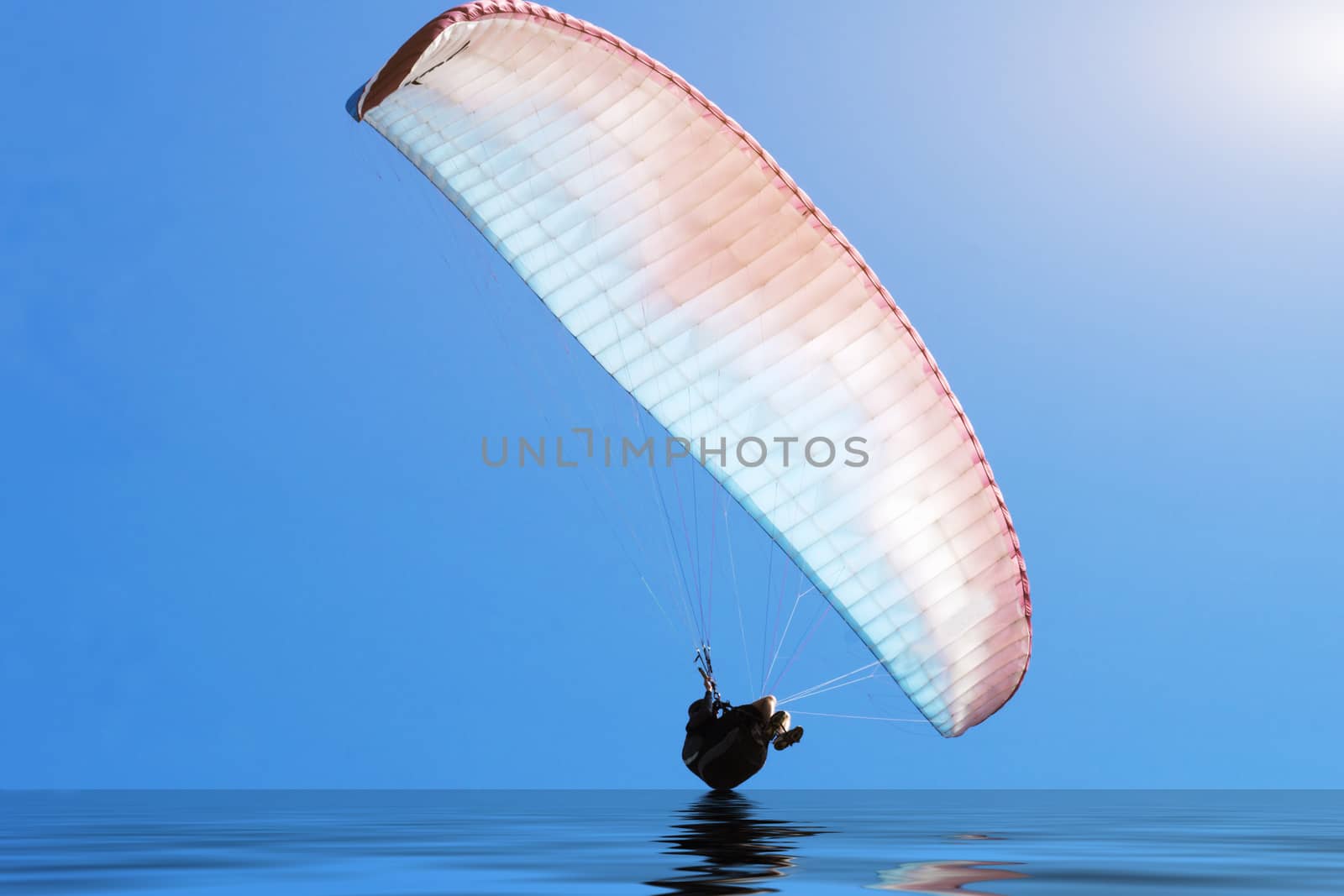 Paragliding over the Danish North Sea coastline on blue sky background