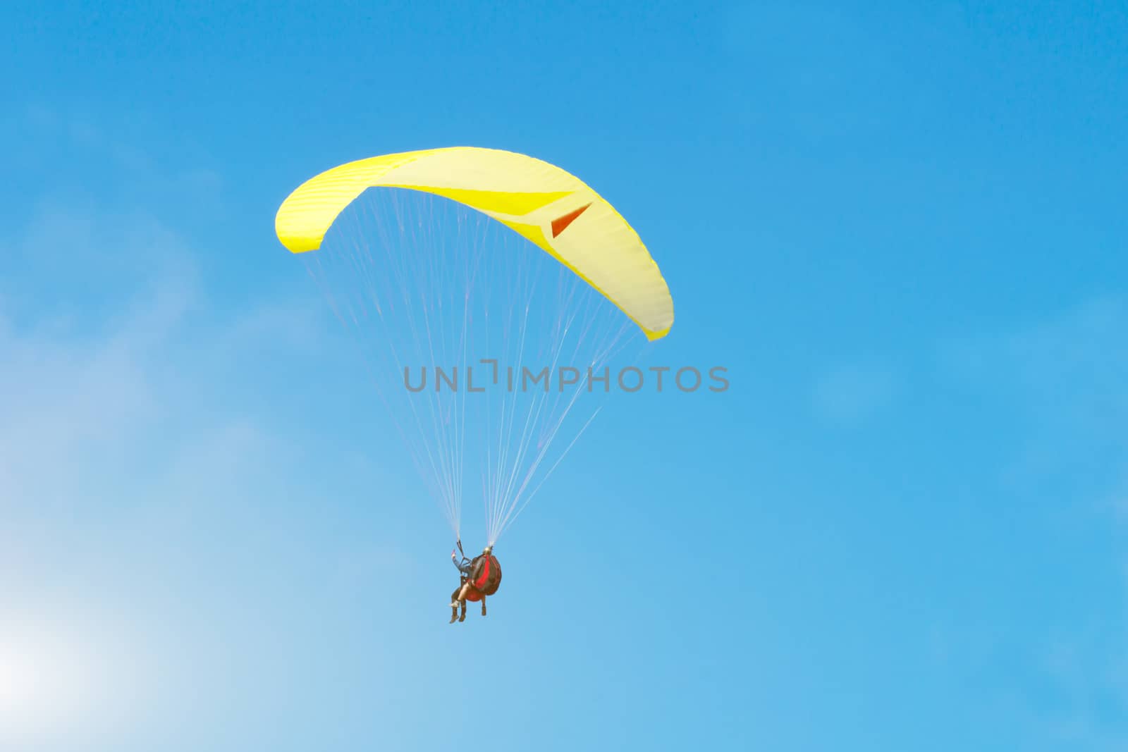 Paragliding over the Danish North Sea coastline on blue sky background