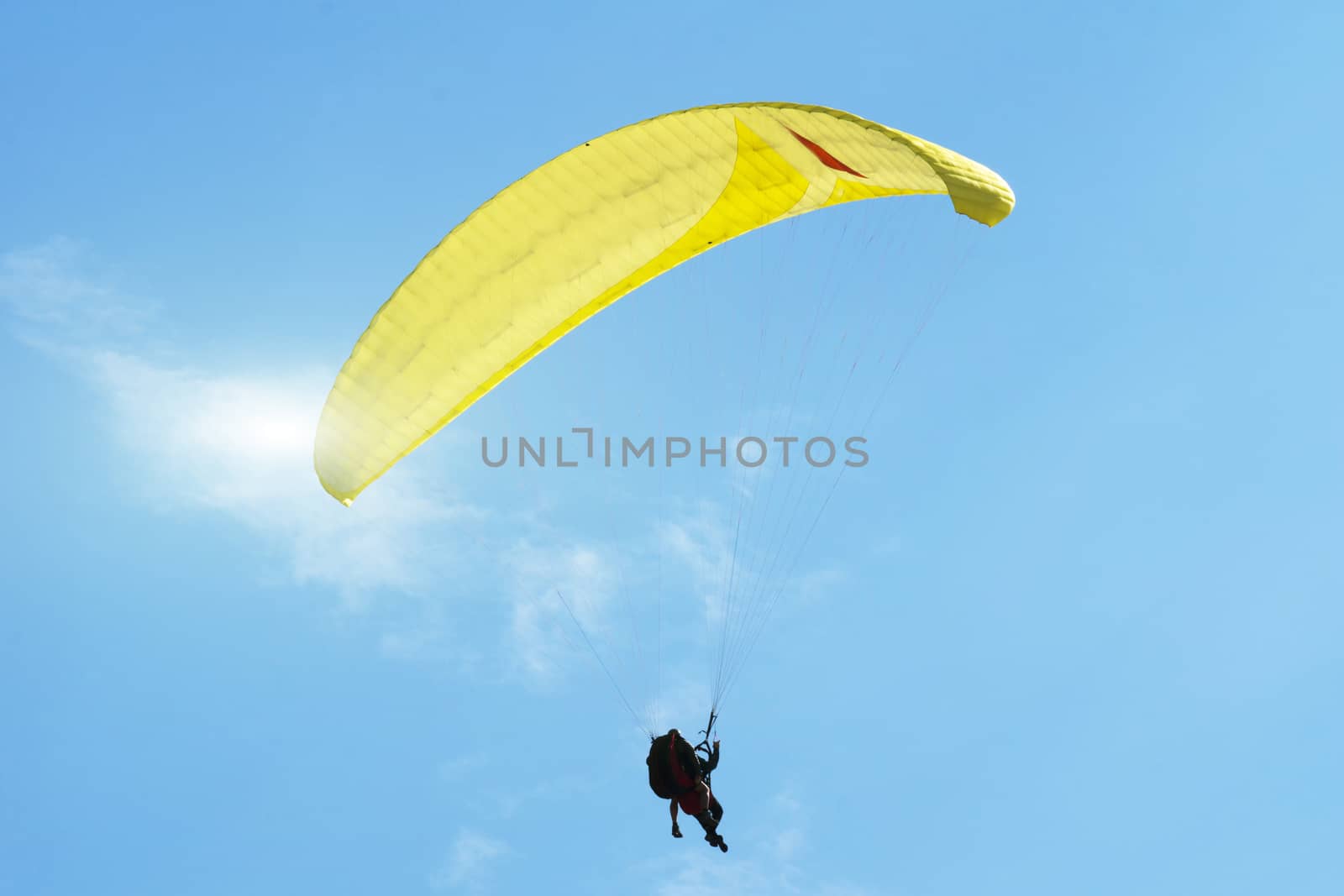 Paragliding over the Danish North Sea coastline on blue sky background