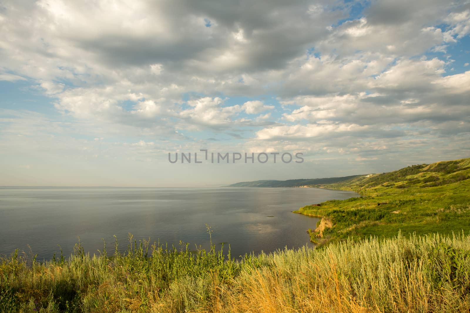 Big river, landscape, green meadow. the cliff and the sky