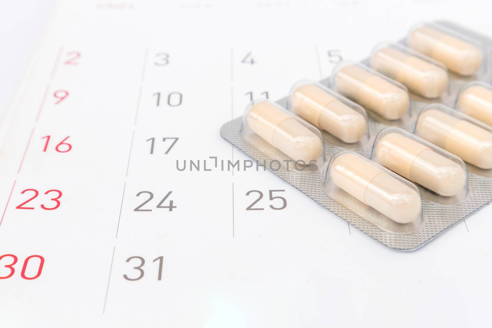 Close up pill with date of calendar background, health care and medicine concept