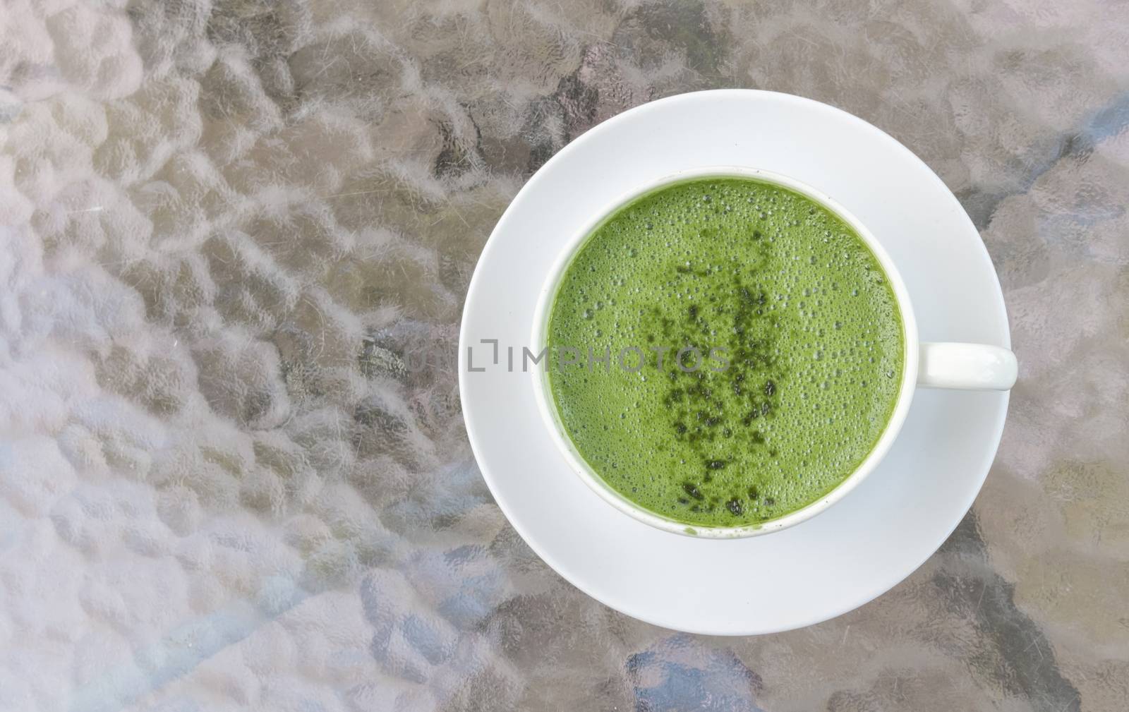 Closeup cup of matcha latte on glass table background by pt.pongsak@gmail.com