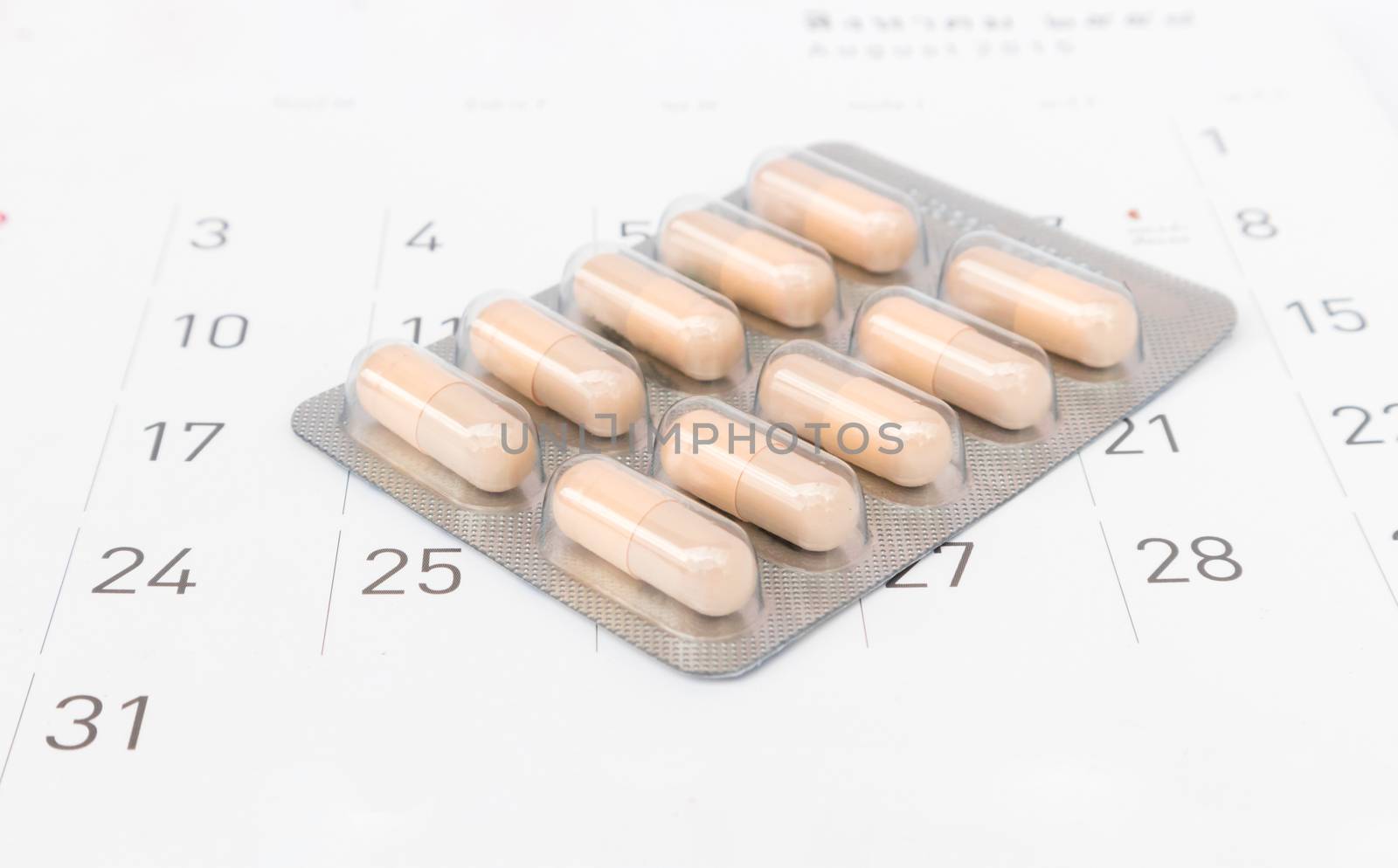 Close up pill with date of calendar background, health care and medicine concept