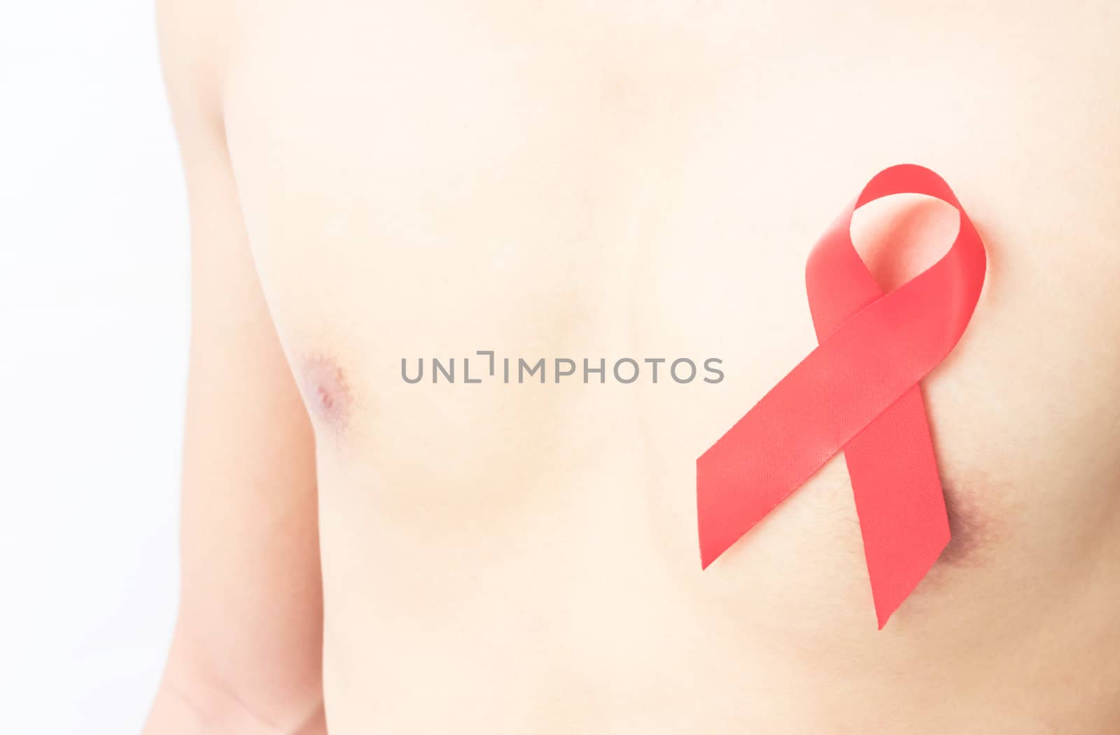 Closeup red ribbon on chest for AIDs awareness concept, health care and medicine by pt.pongsak@gmail.com