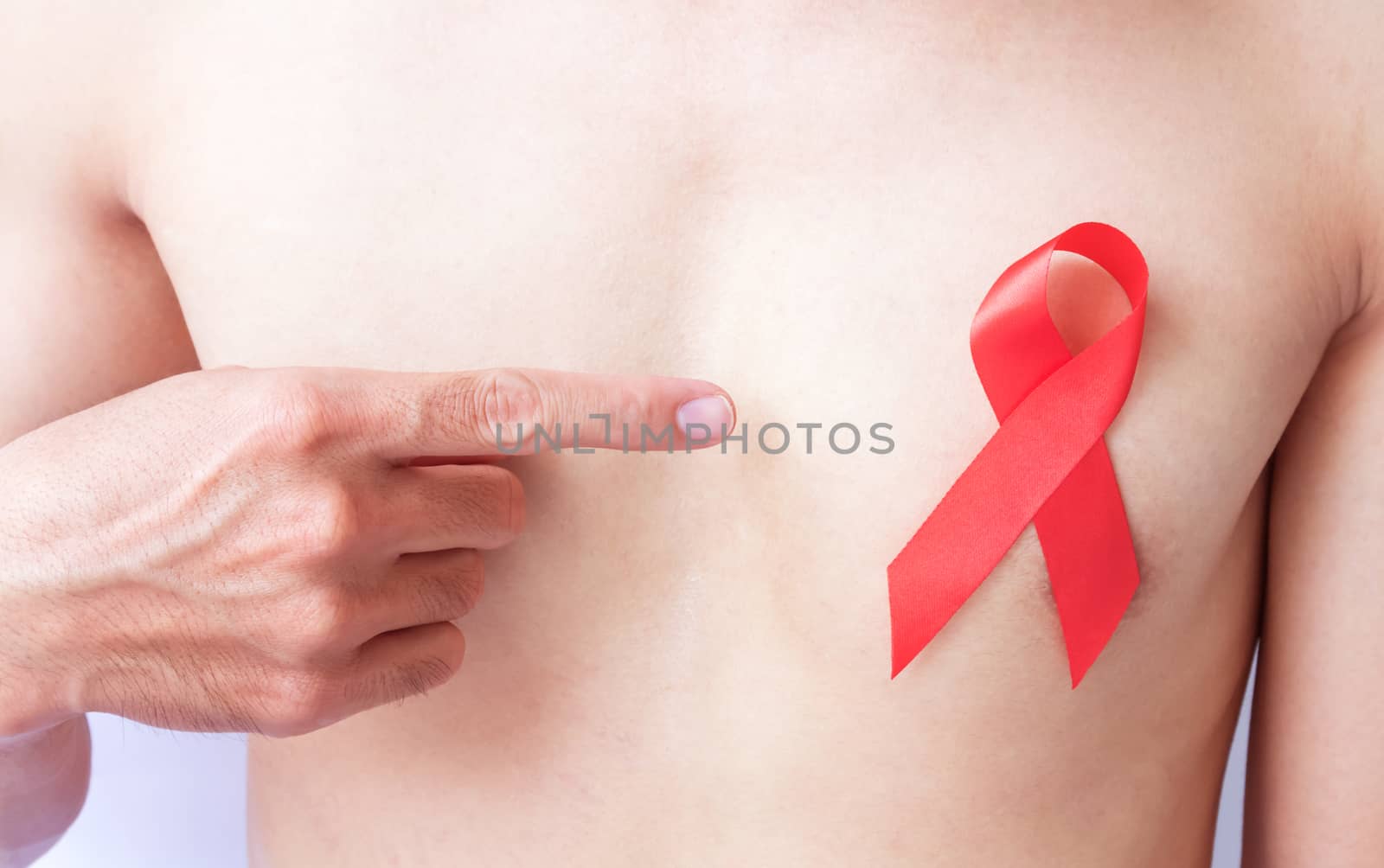 Hand pointer finger to red ribbon on chest for AIDs awareness by pt.pongsak@gmail.com