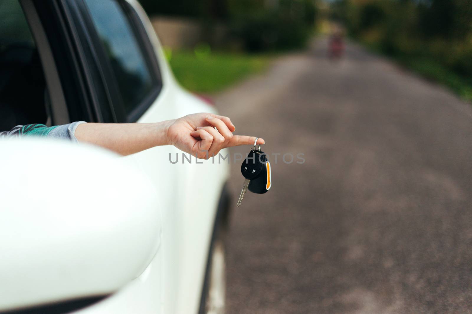 Closeup of car keys hanging on female finger