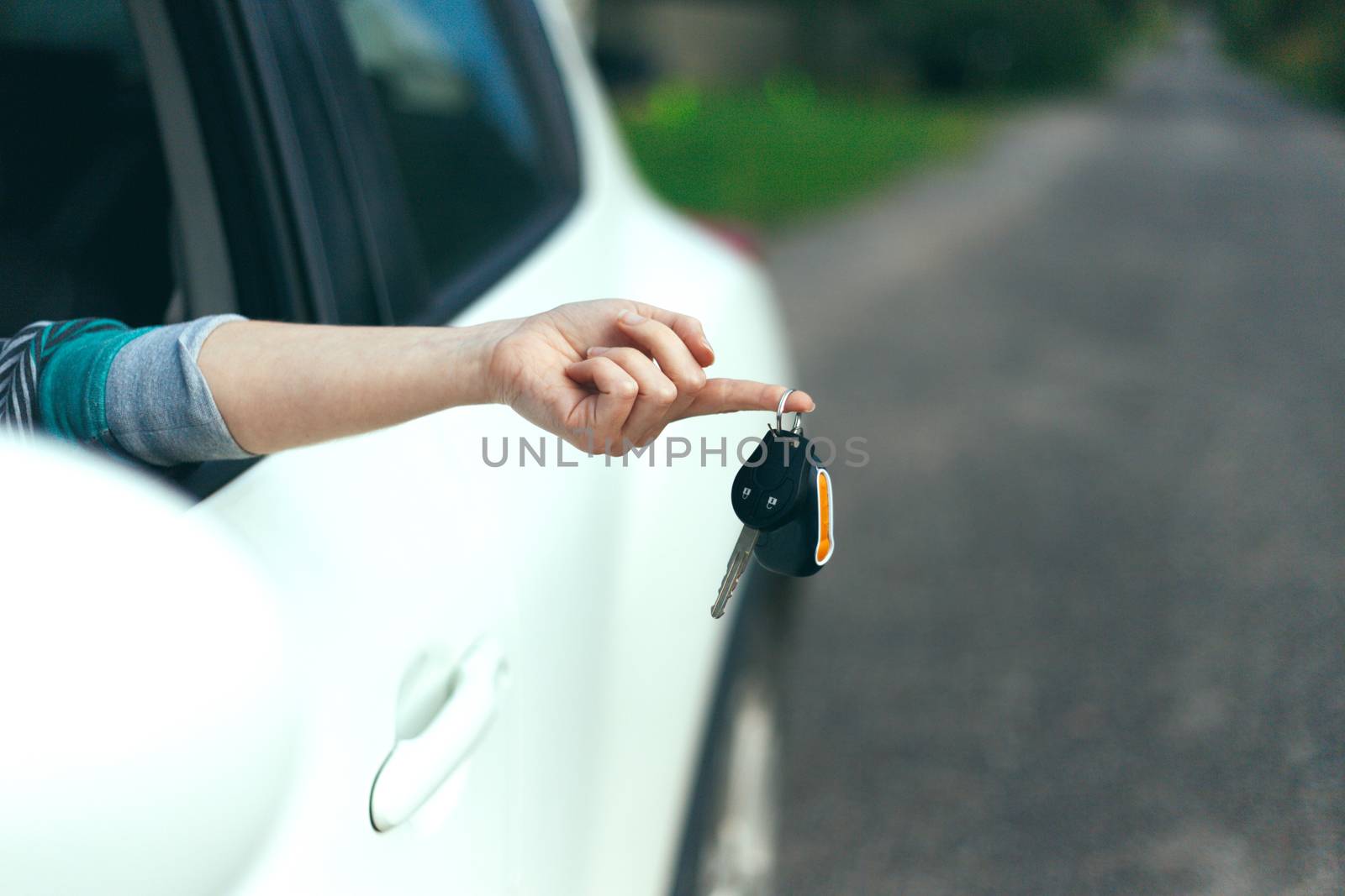Closeup of car keys hanging on female finger