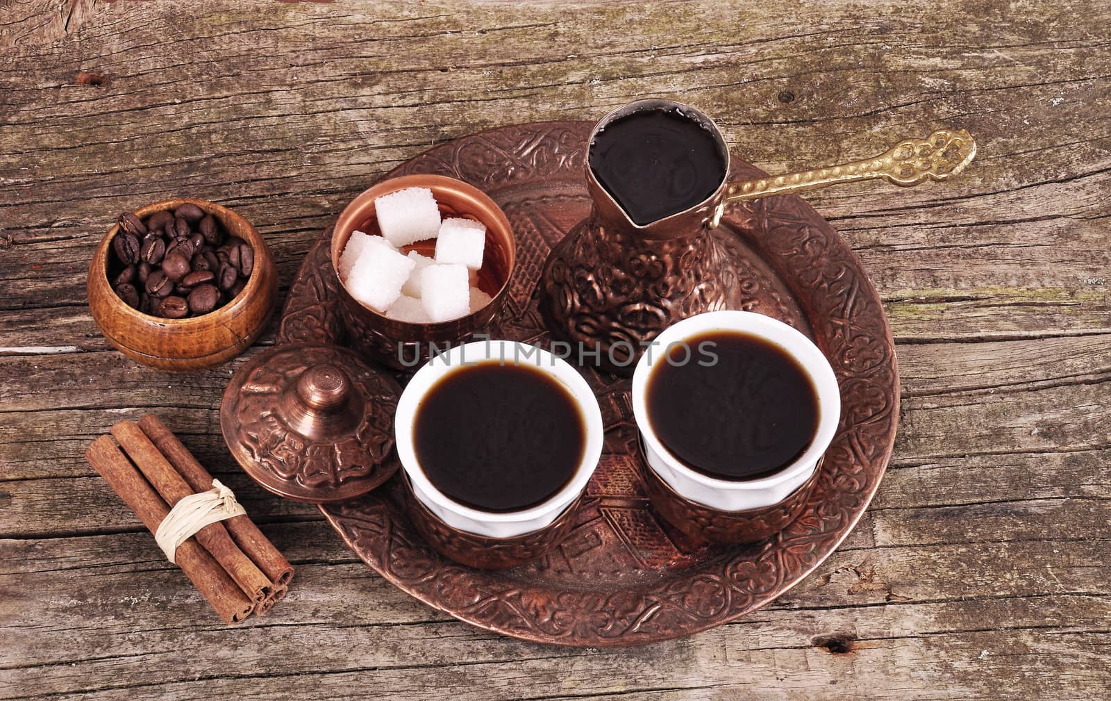 Coffee in copper coasters with accessories for coffee-drinking on old wooden background