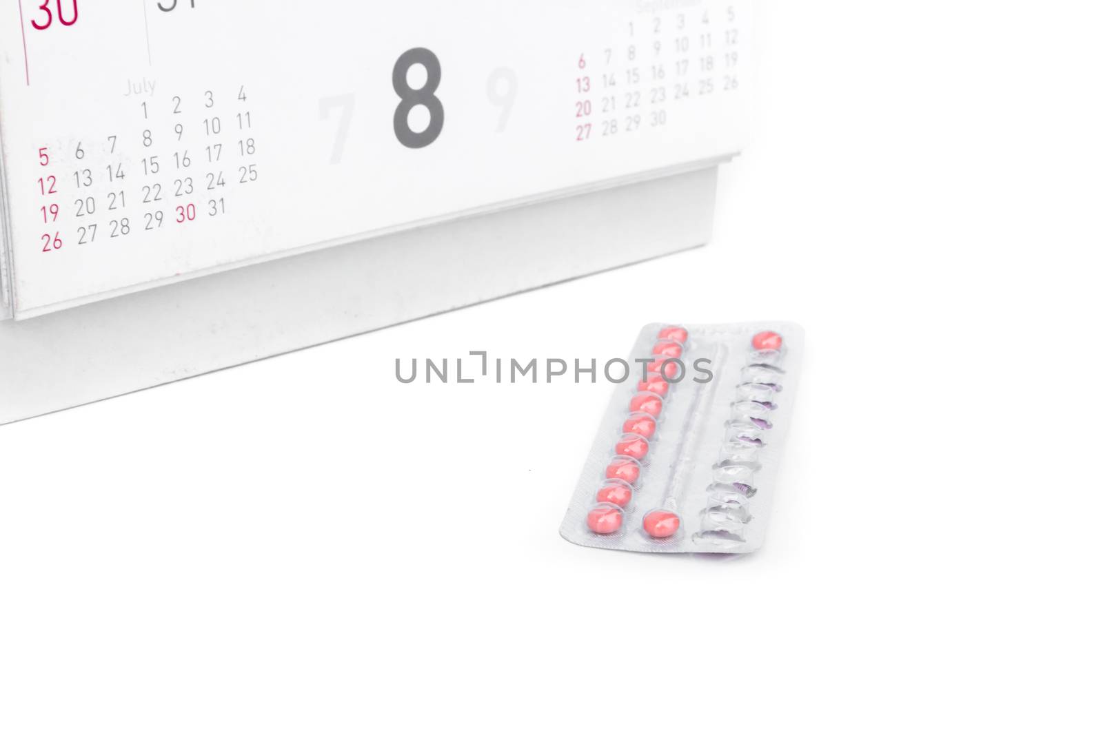 Close up birth-control pill with date of calendar background, health care and medicine concept