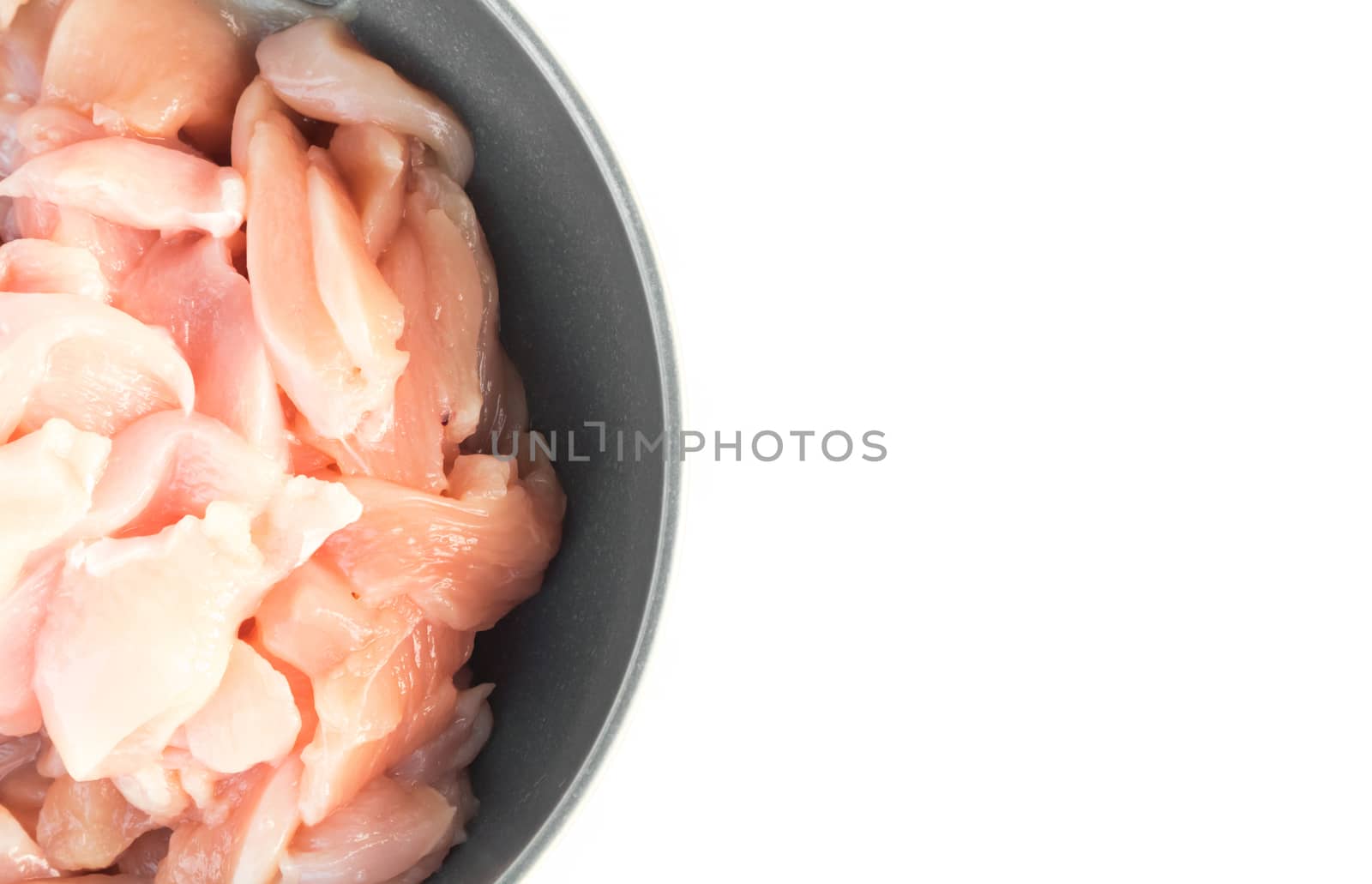 Close up top view pieces of raw chicken fillet in bowl on white background, raw material for cooking