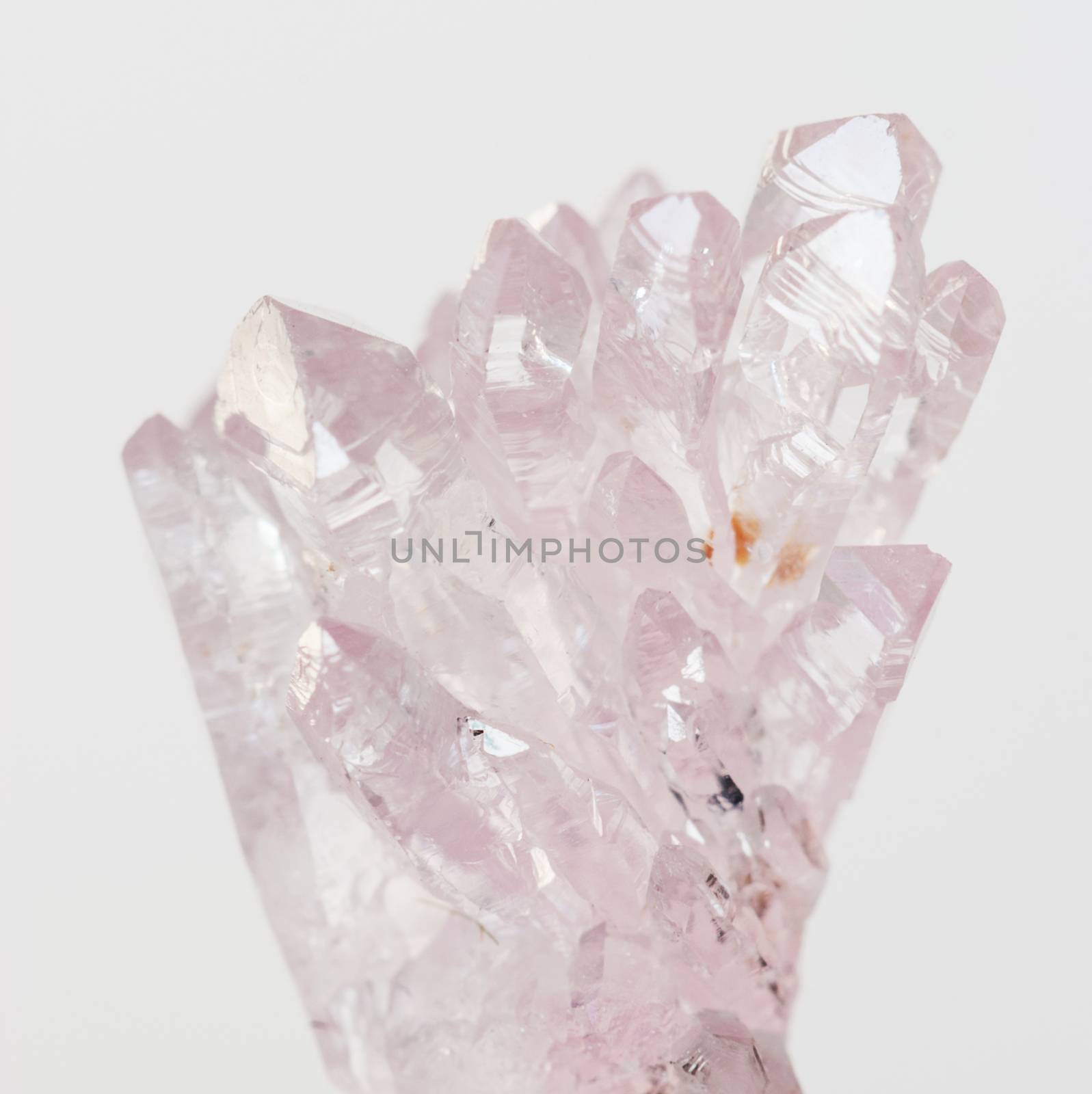 Beautiful cluster of transparent crystals of natural pink quartz gemstone amethyst on a white background