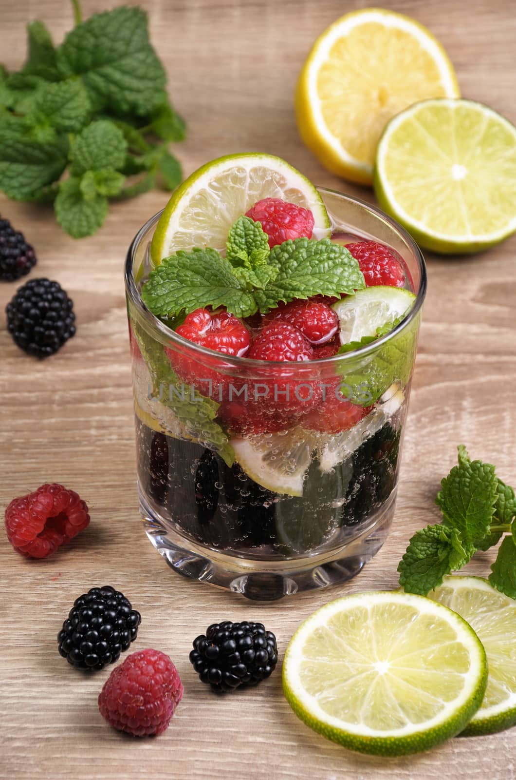 A glass of lemonade from the berries of blackberry and raspberry with lime and mint