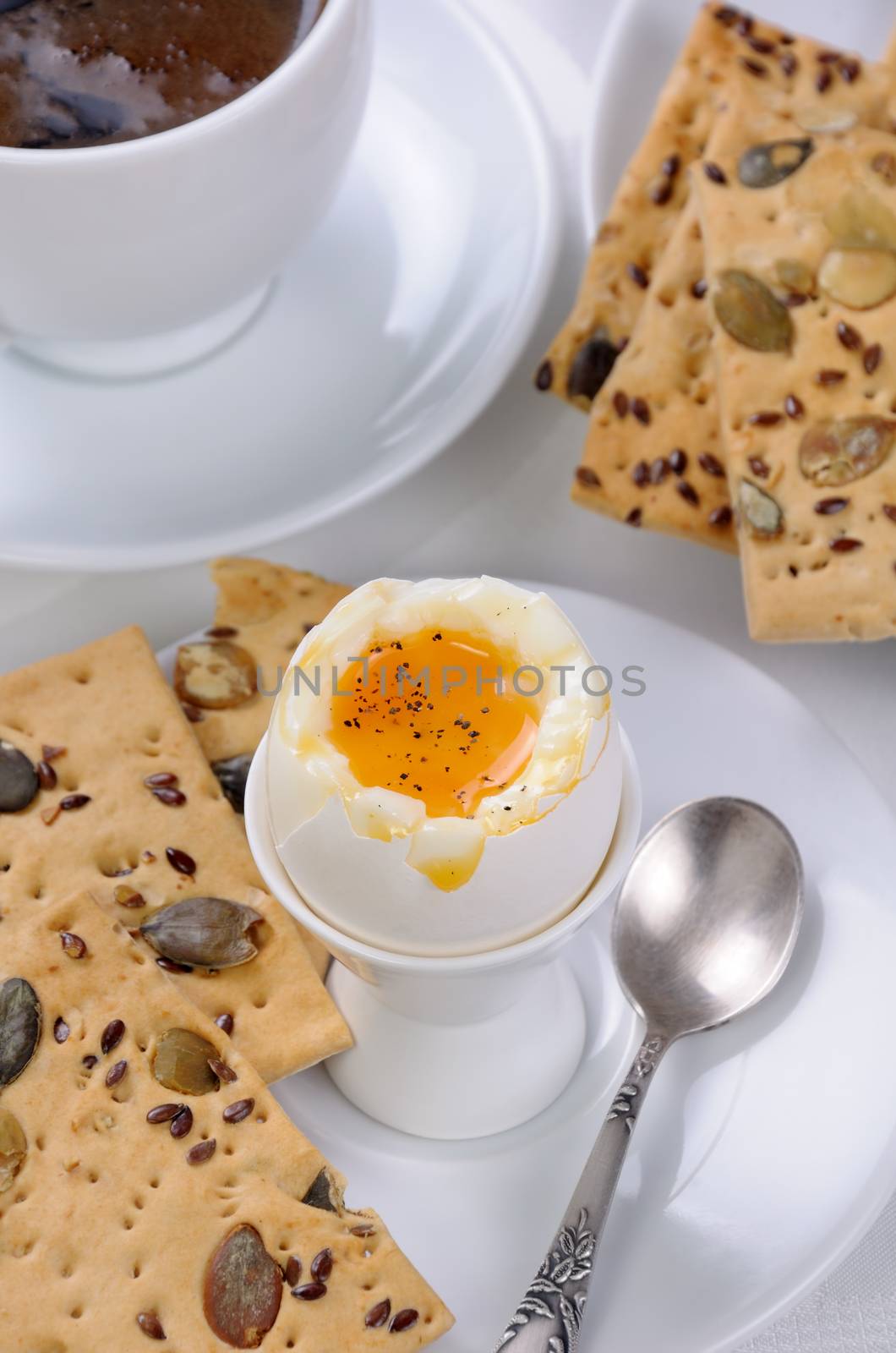 Soft-boiled egg with cup of coffee and crackers for breakfast