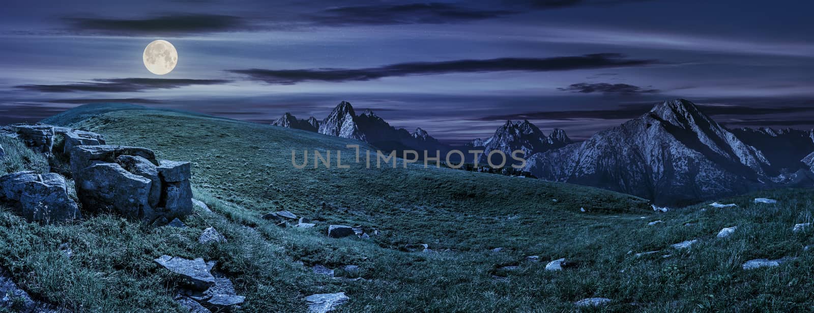 huge stones in valley on top of mountain range at night by Pellinni