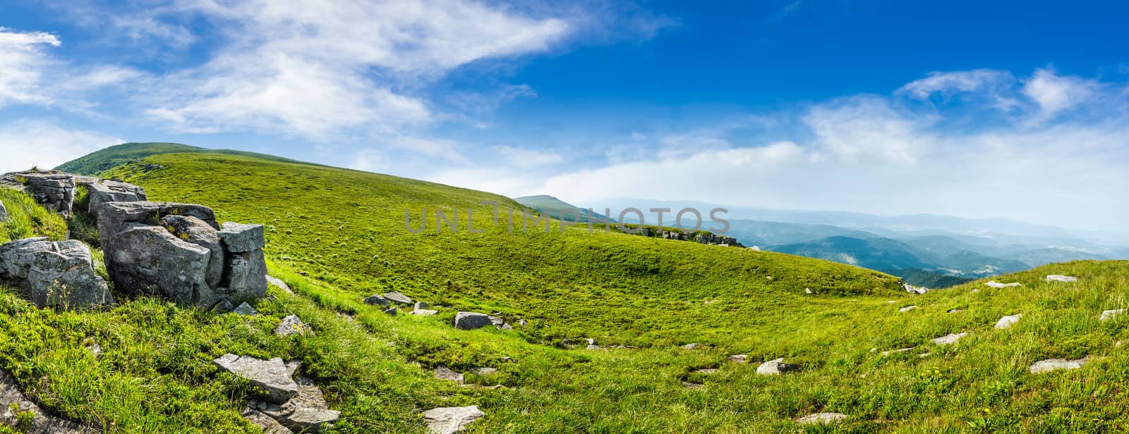 mountain summer landscape. meadow with huge stones among the grass on top of the hillside near the peak of mountain range