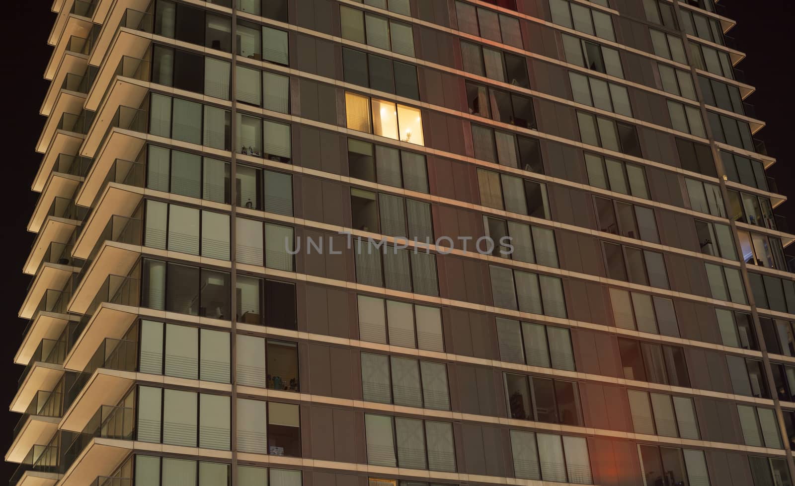 Single light on in modern apartment block