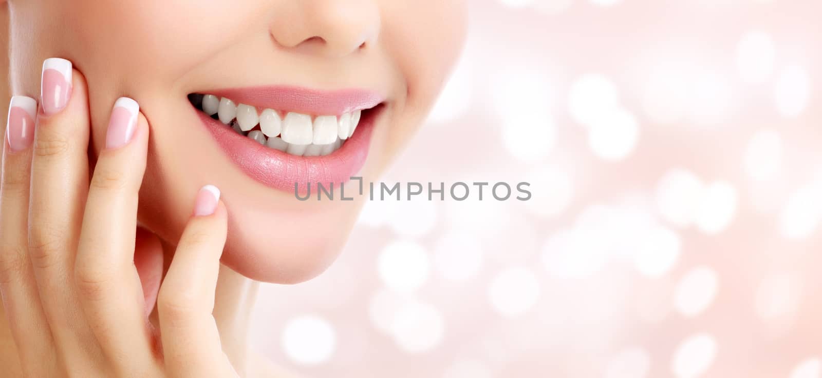 Closeup shot of beautiful female smile, abstract background with blurred lights