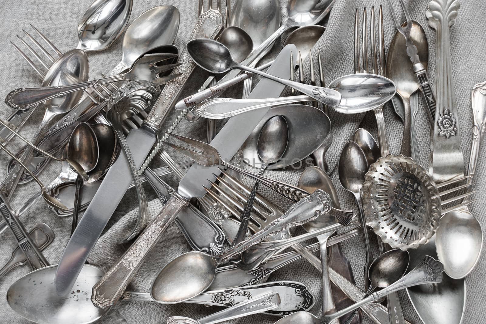 Various silverware on a background of gray linen fabric