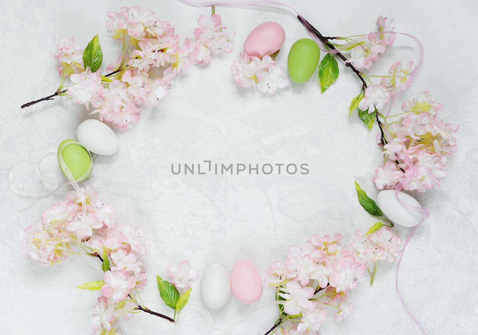 Beautiful delicate Easter composition with pink cherry flowers and multicolored Easter eggs
