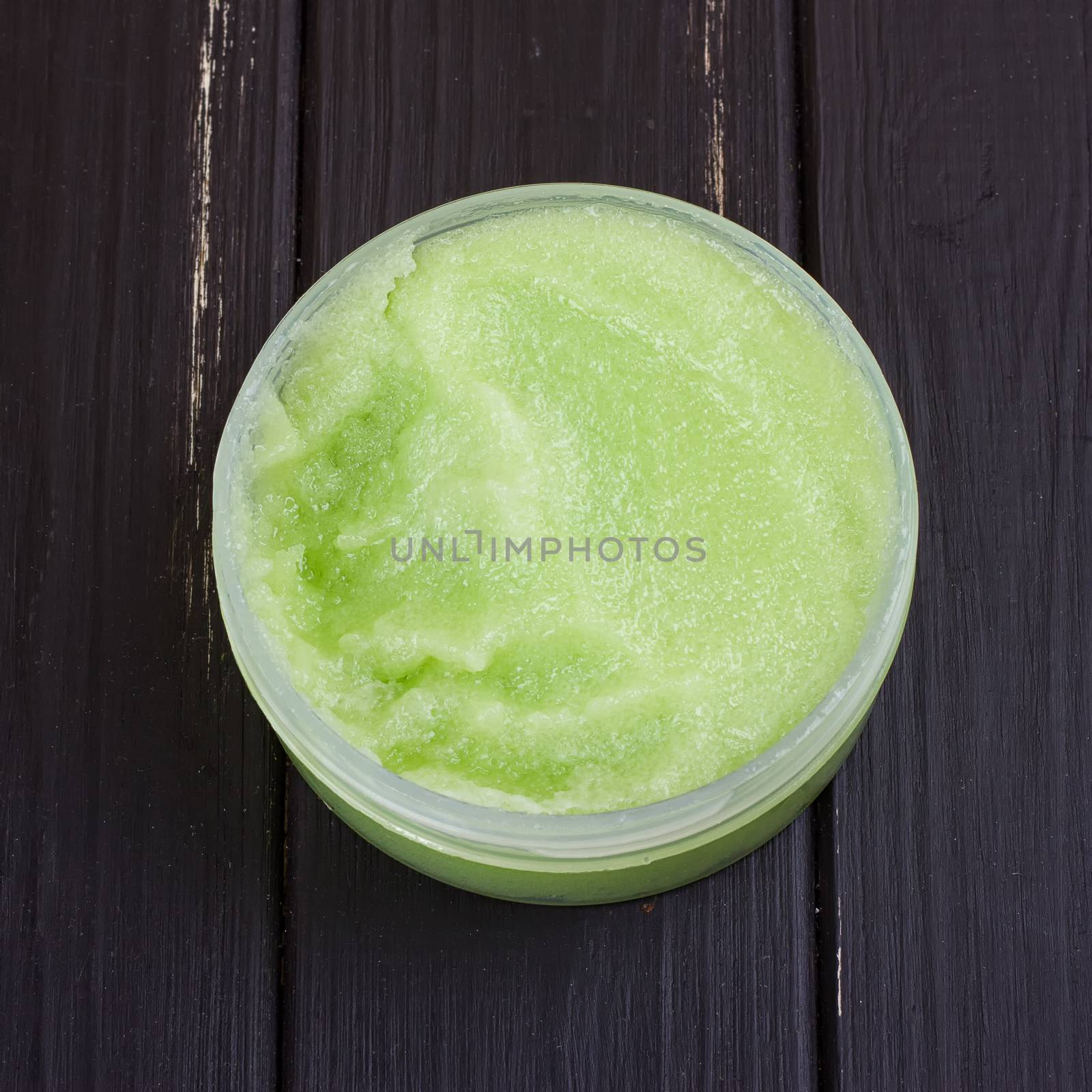 green body scrub on the black wooden background