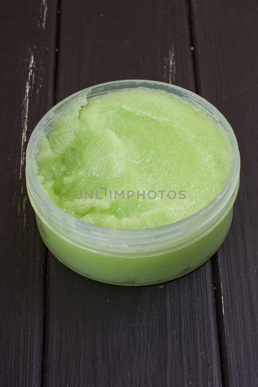 green body scrub on the black wooden background