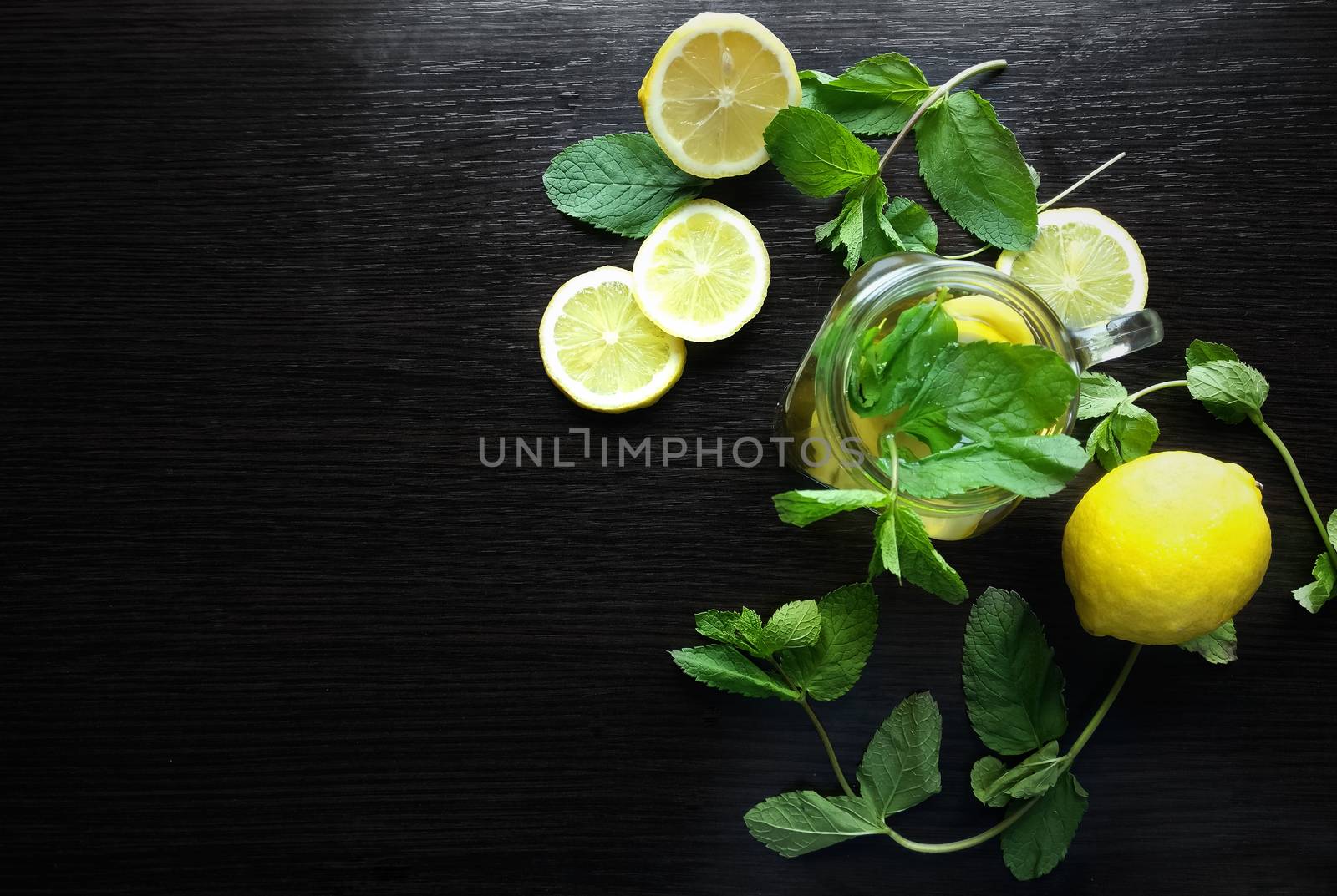 Mint herbal tea in glass cup on wooden background by natali_brill