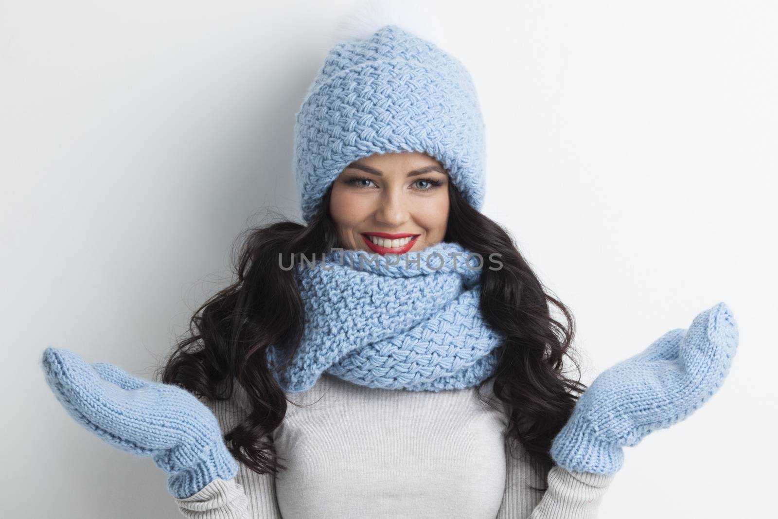 Beautiful woman in warm hat, mittens and scarf on white background