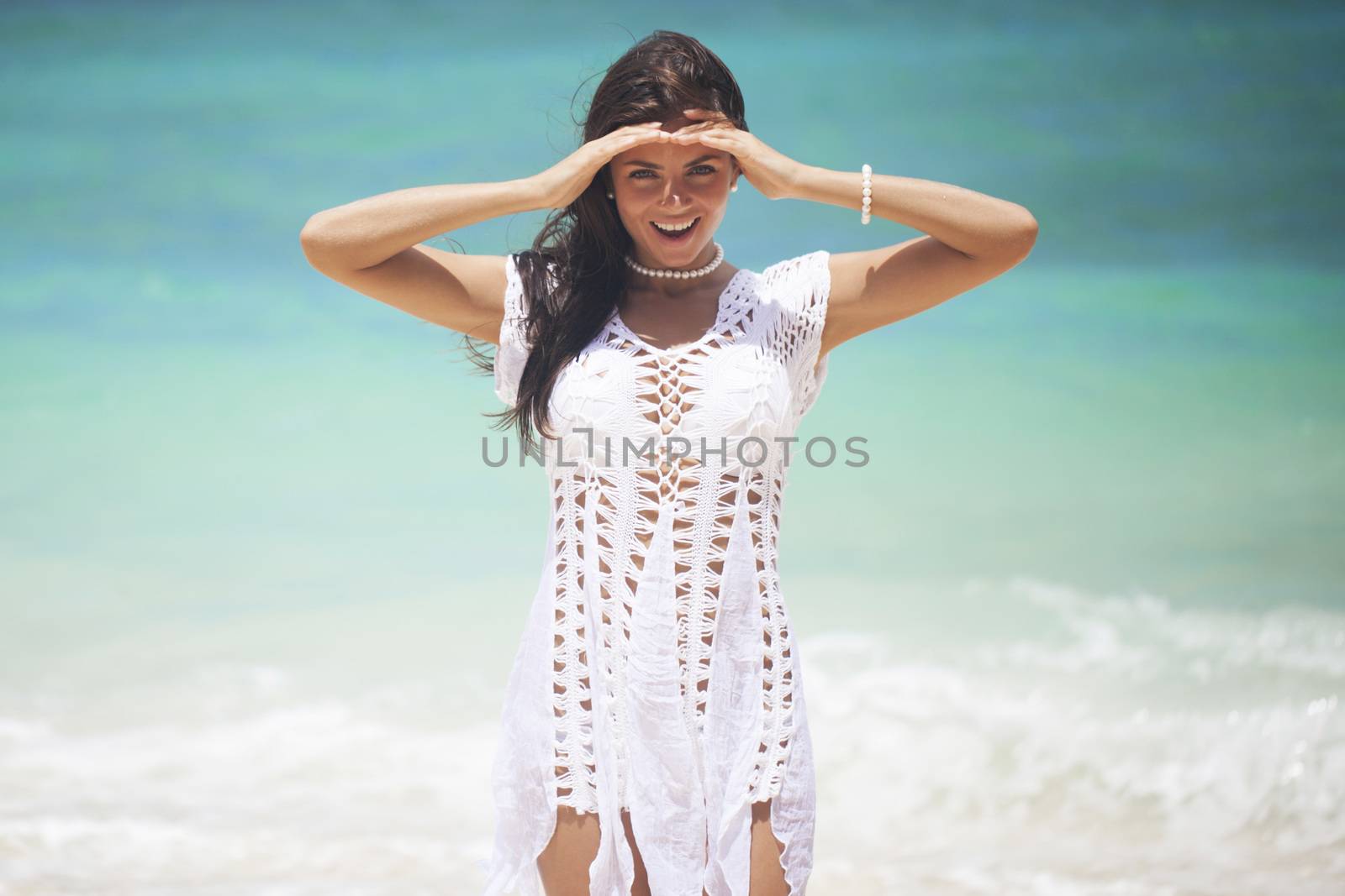 Woman in white dress posing in tropical sea beach