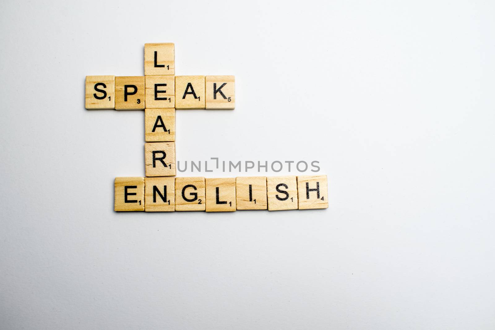 Scrabble tiles disposed in crosswords on a white background