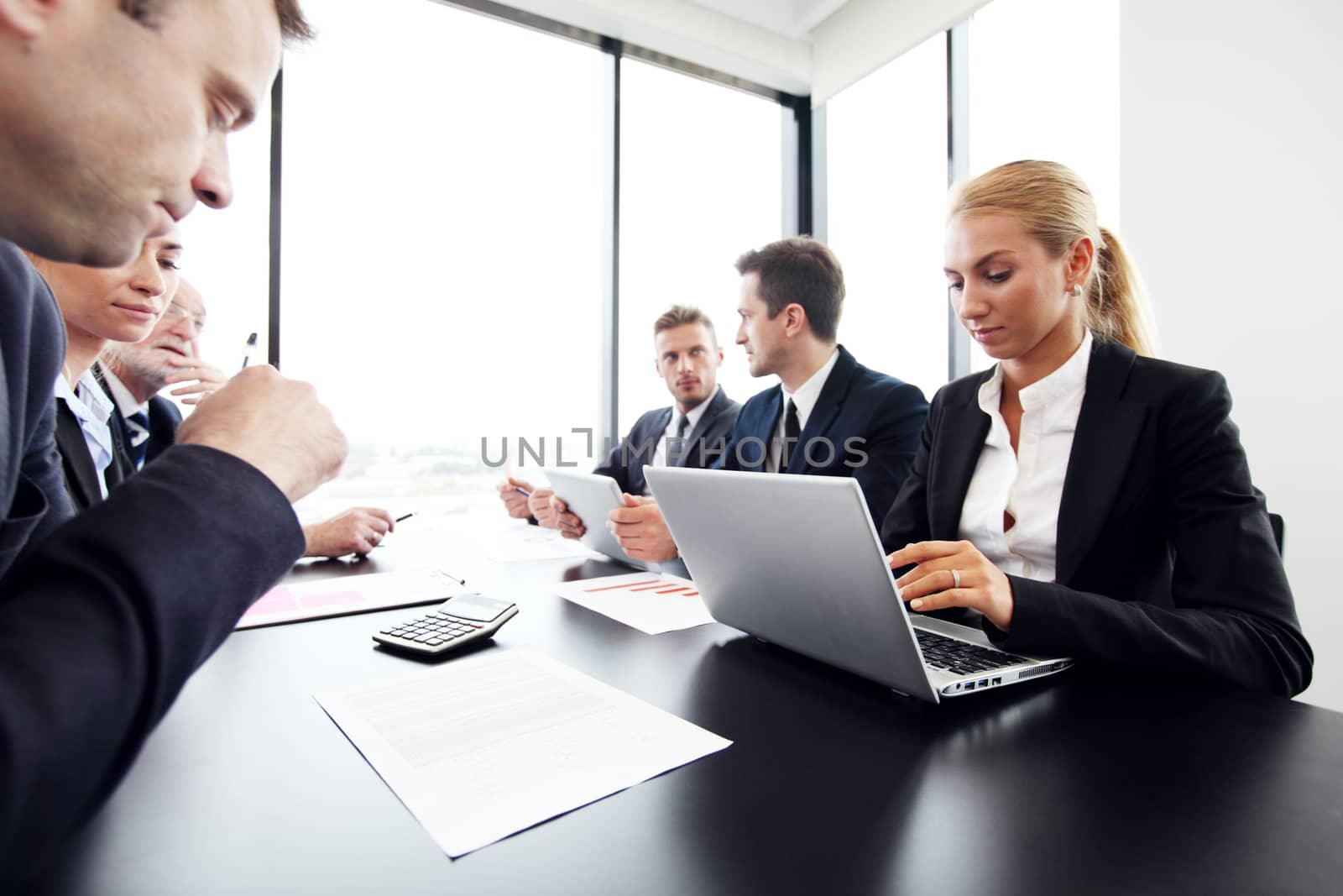 Mixed group of people in business meeting working with documents and computers