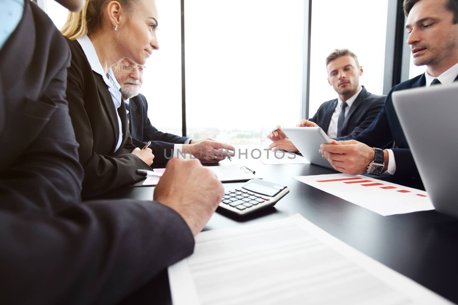 Mixed group of people in business meeting working with documents and computers