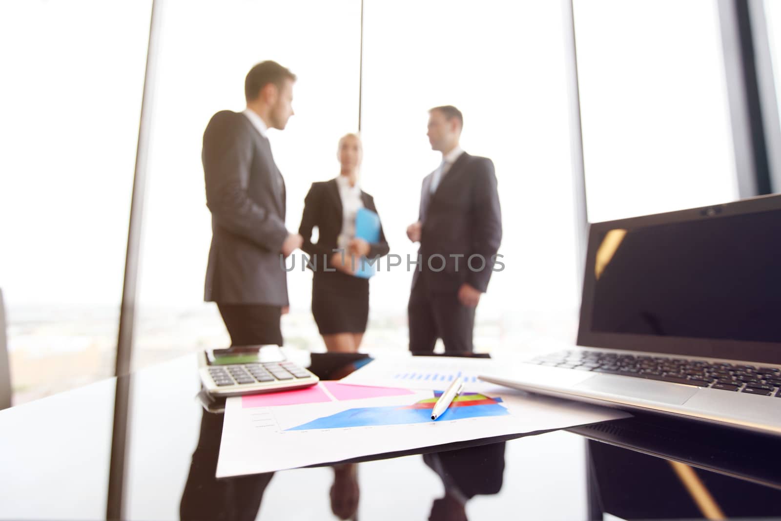 Mixed group of people in business meeting working with documents and computers